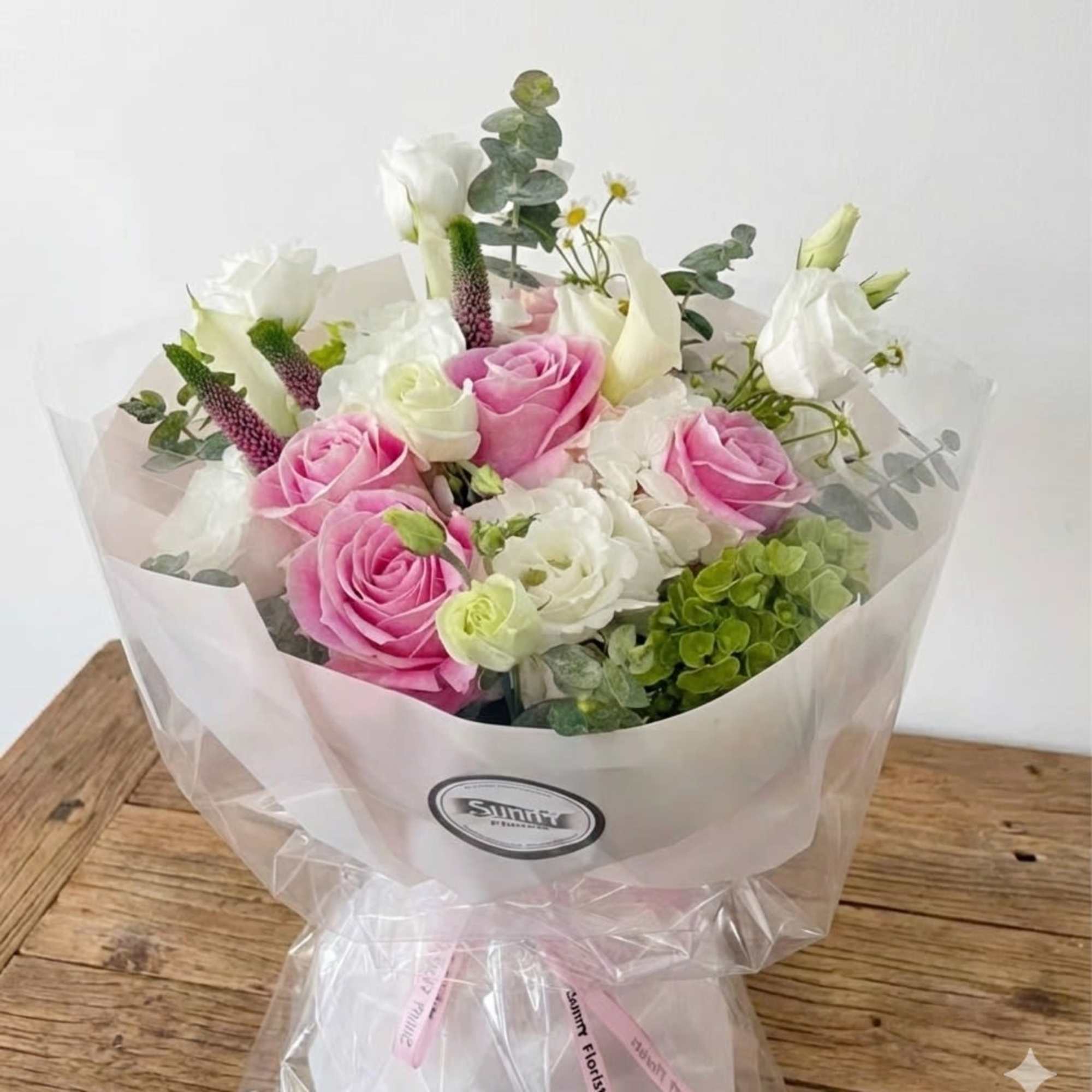 This pastel-colored handtied bouquet includes beautiful pink vandal roses, complemented by white