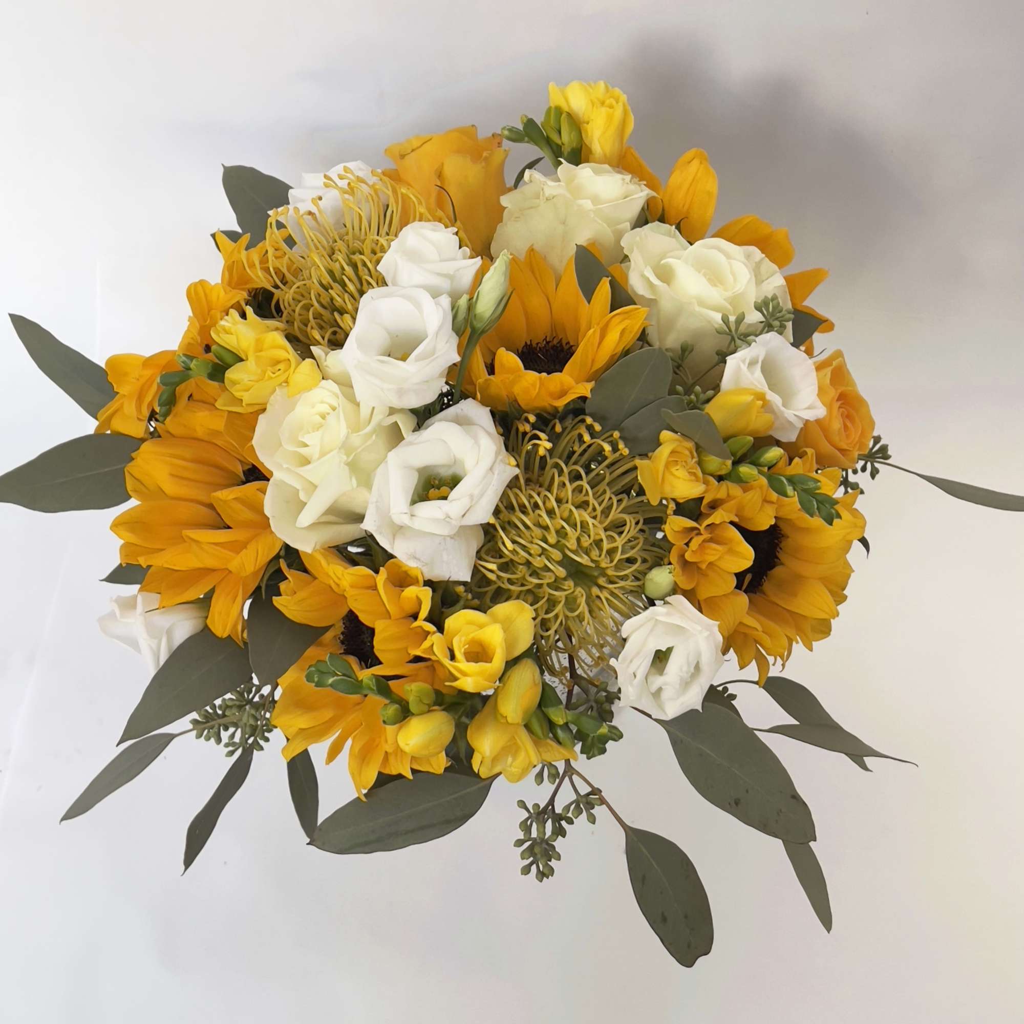 A yellow and white floral arrangement in a vase, designed to add