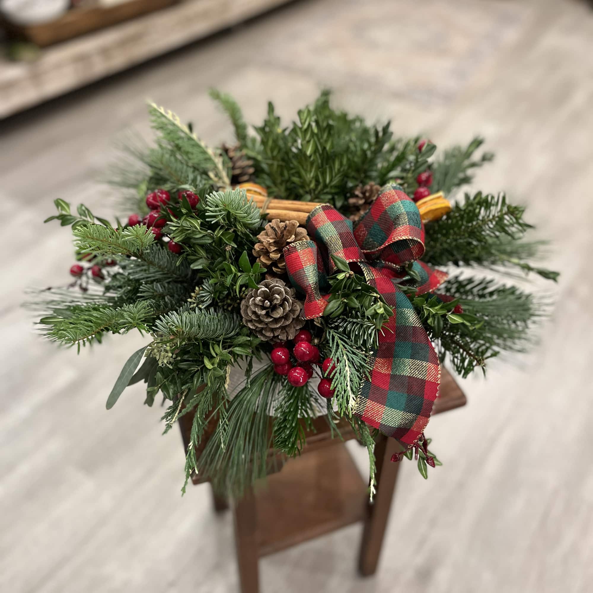 This lush and full display is an enticing mix of evergreens, pinecones