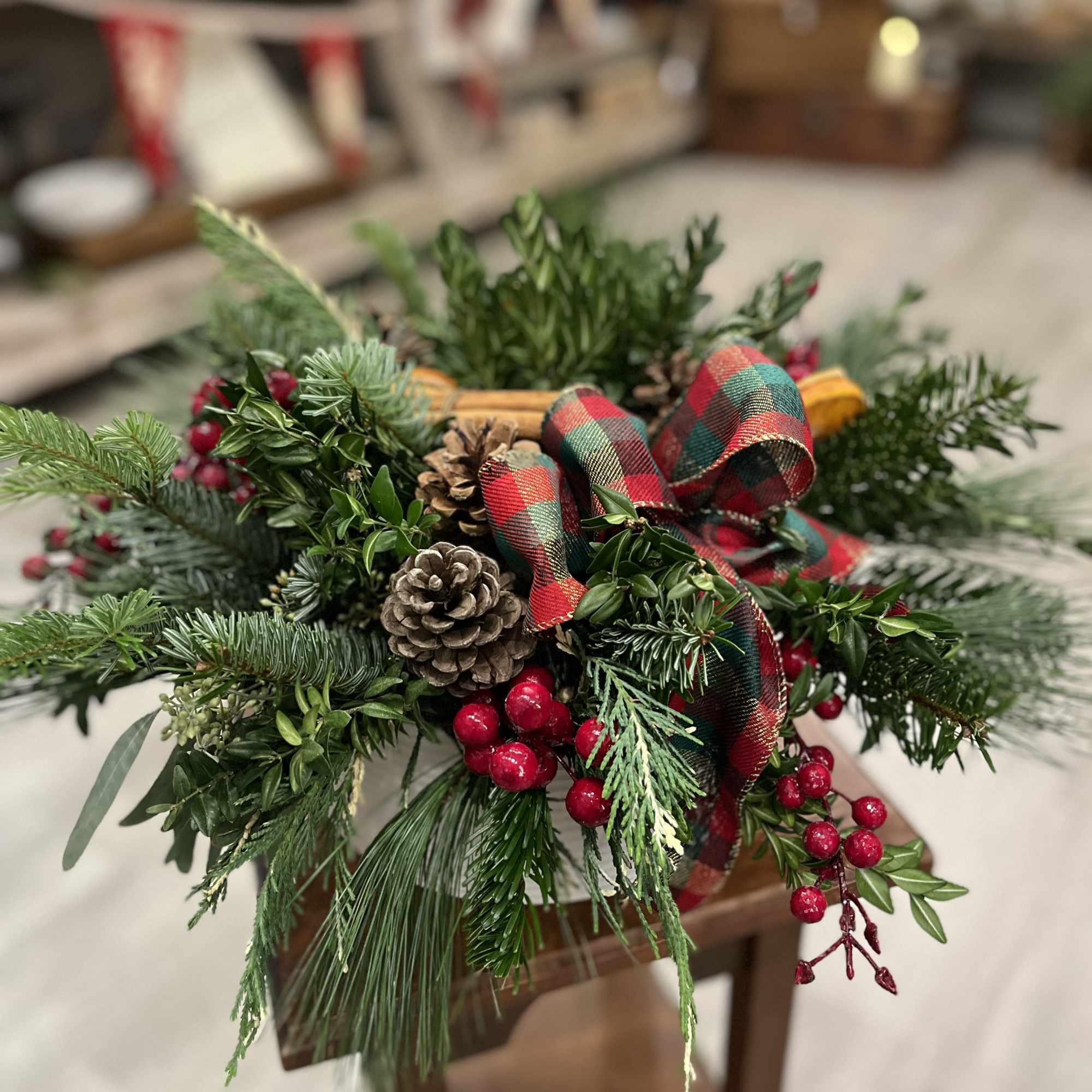 This lush and full display is an enticing mix of evergreens, pinecones