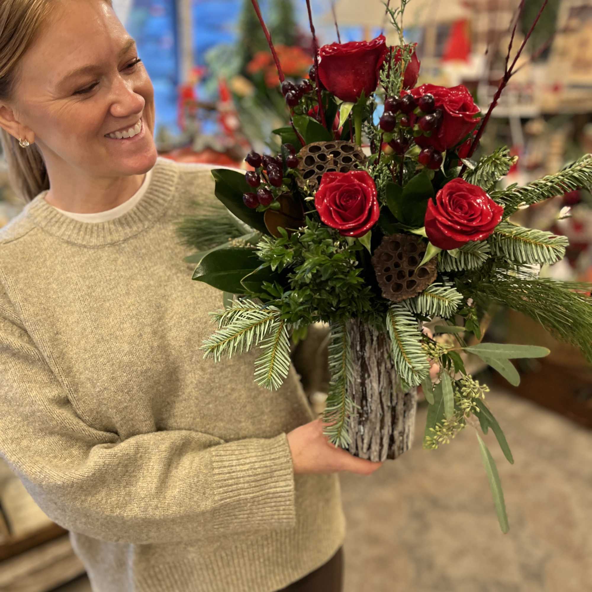 A rustic, bark enrobed vase is overflowing with fresh cut pine, cedar