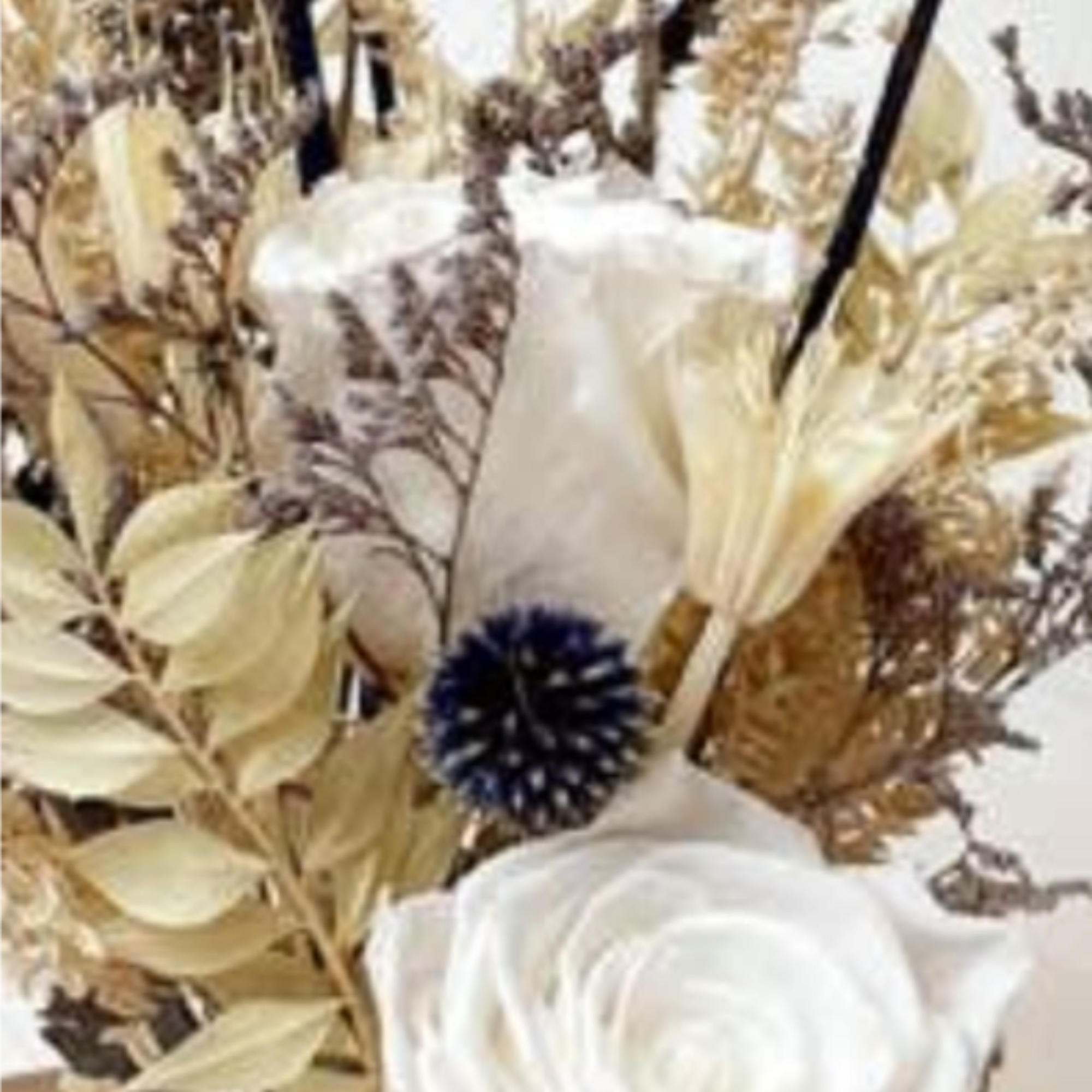 A preserved real rose is arranged among a mix of natural botanicals