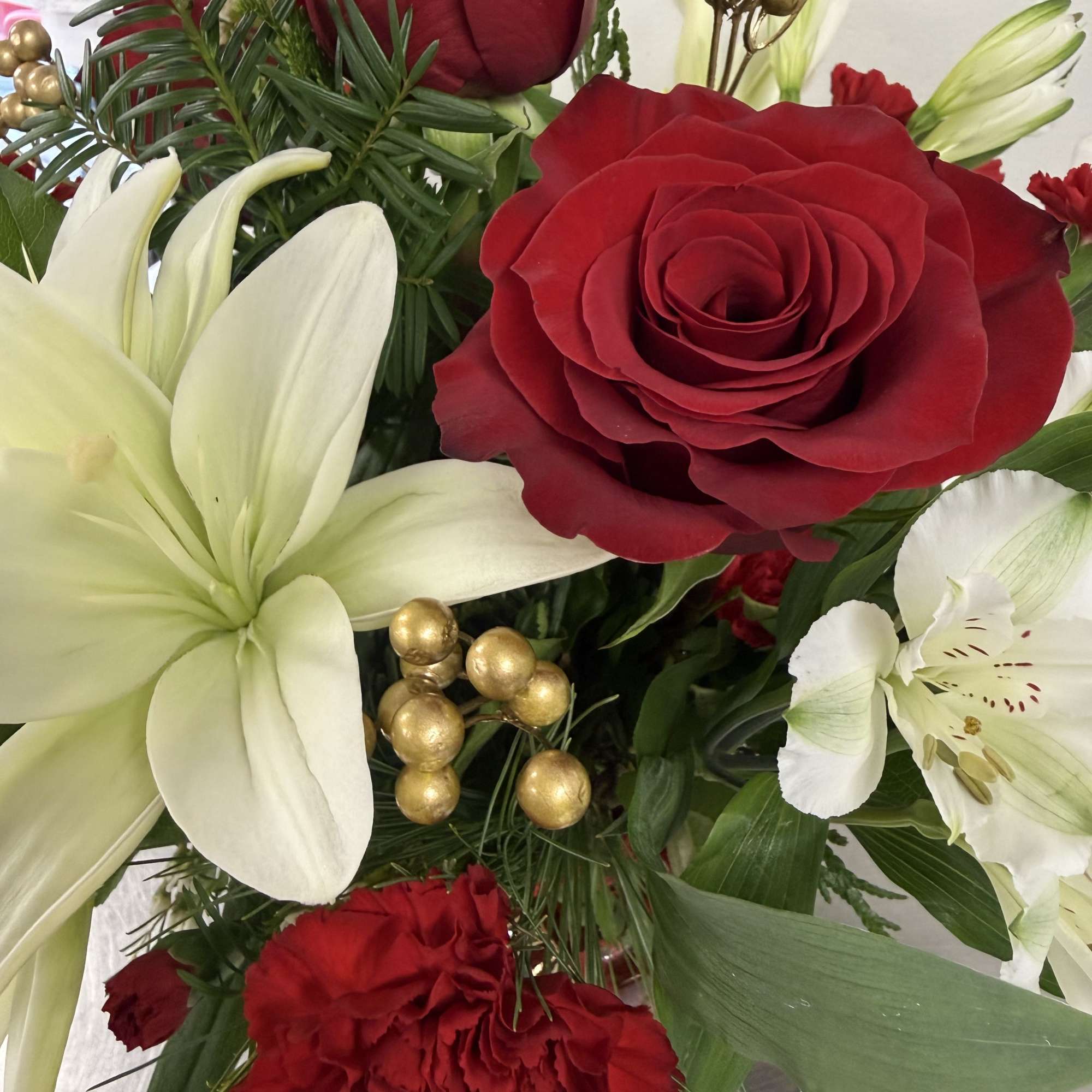 A ruby red and white Holiday arrangement that focuses on white asiatic