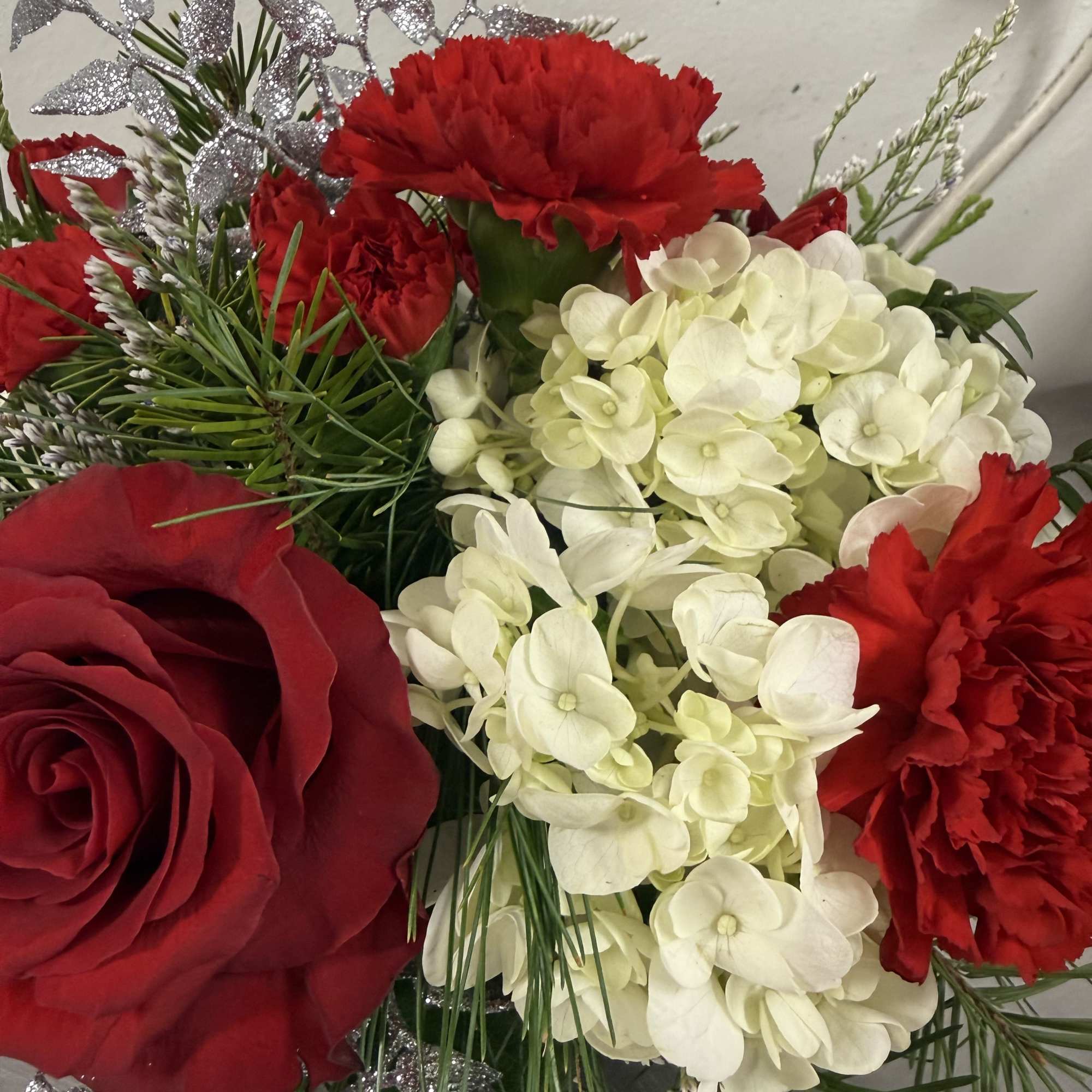 A beautiful winter arrangement designed in a glass cube with a reindeer