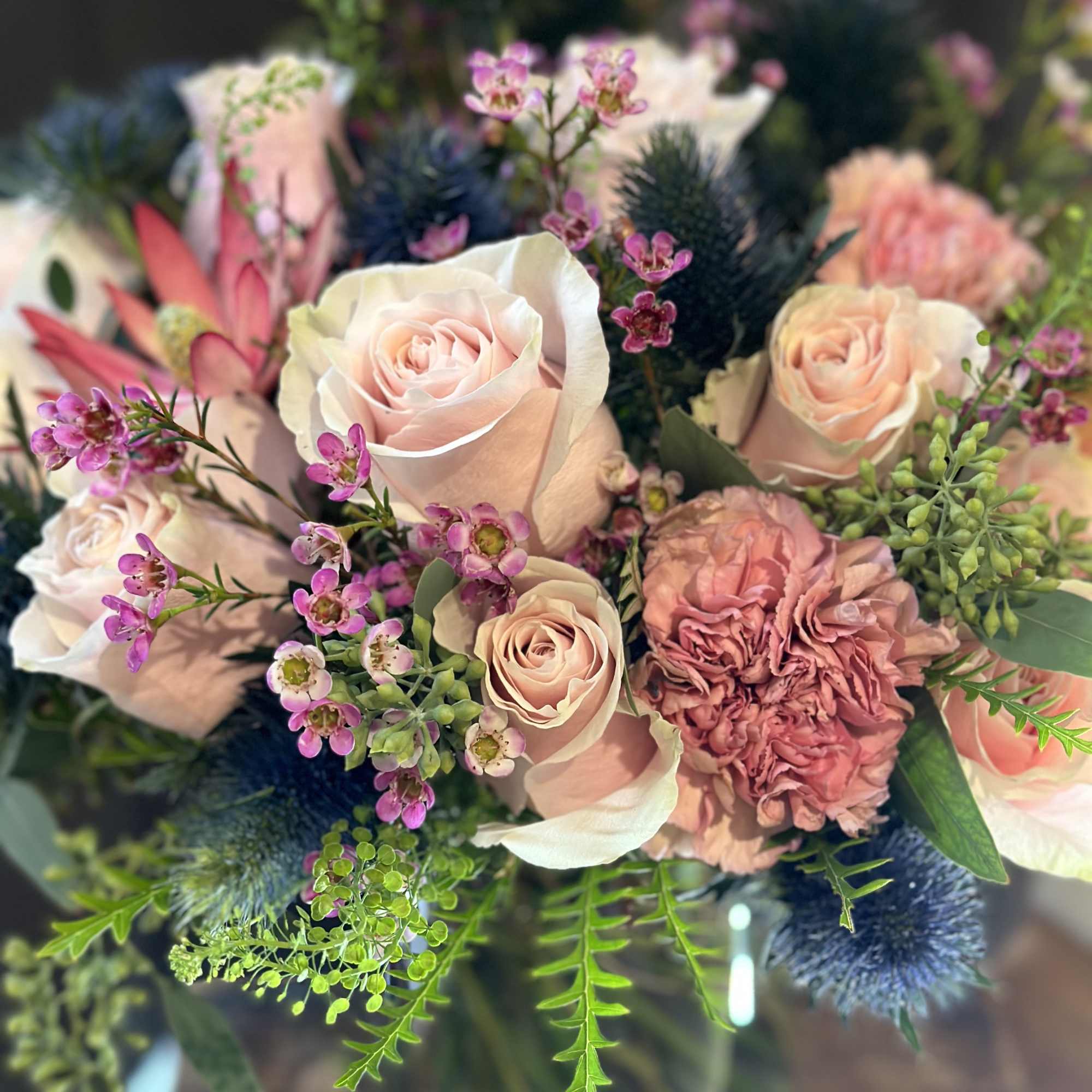 Blush roses with blue thistle. 