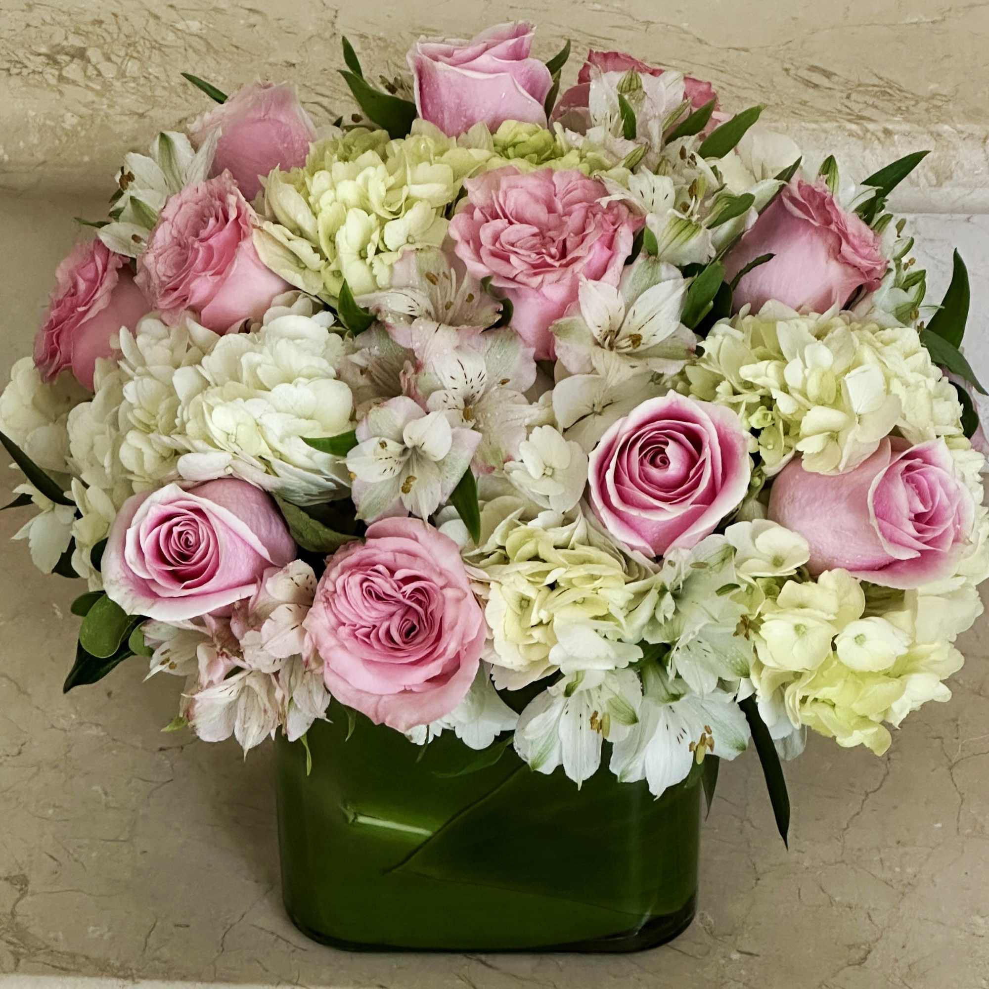 Pink Roses with White Hydrangeas arranged in a square glass vase.