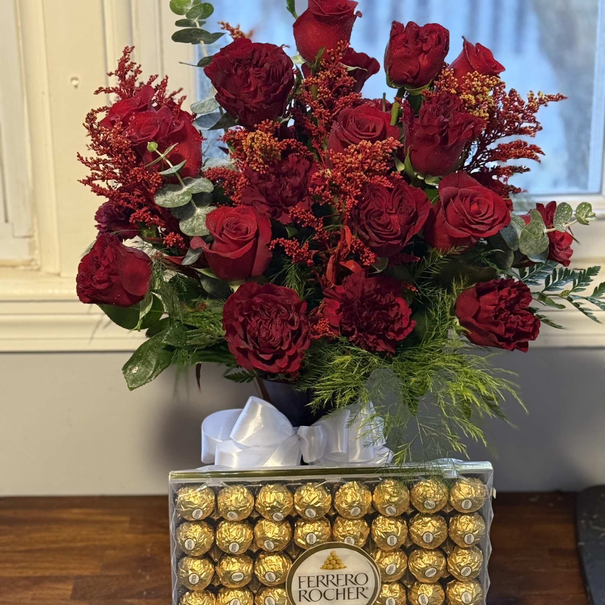2 dozen perfectly paired red roses with assortment of greens and filler