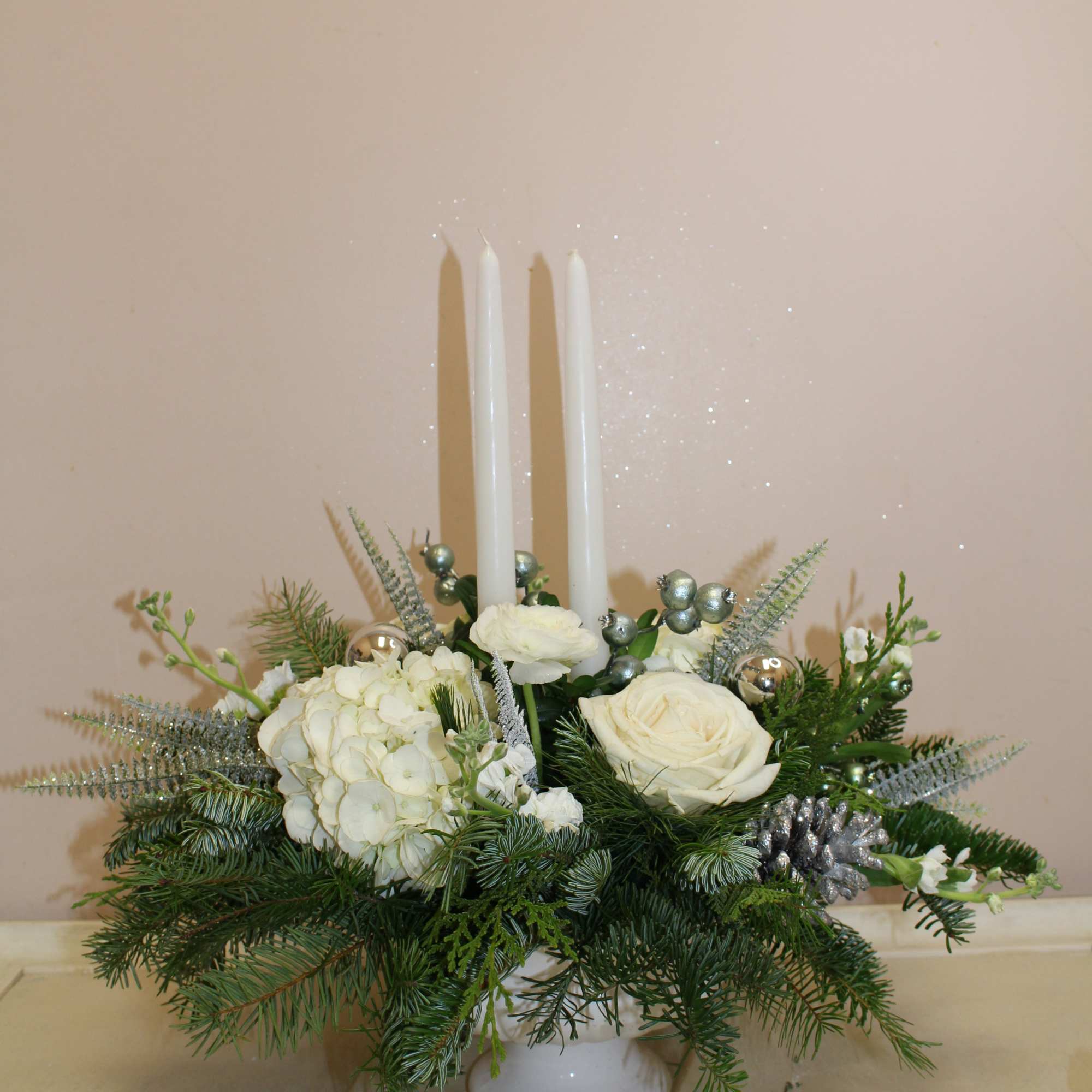 A white ceramic pedestal filled with white hydrangea roses and lisianthus 