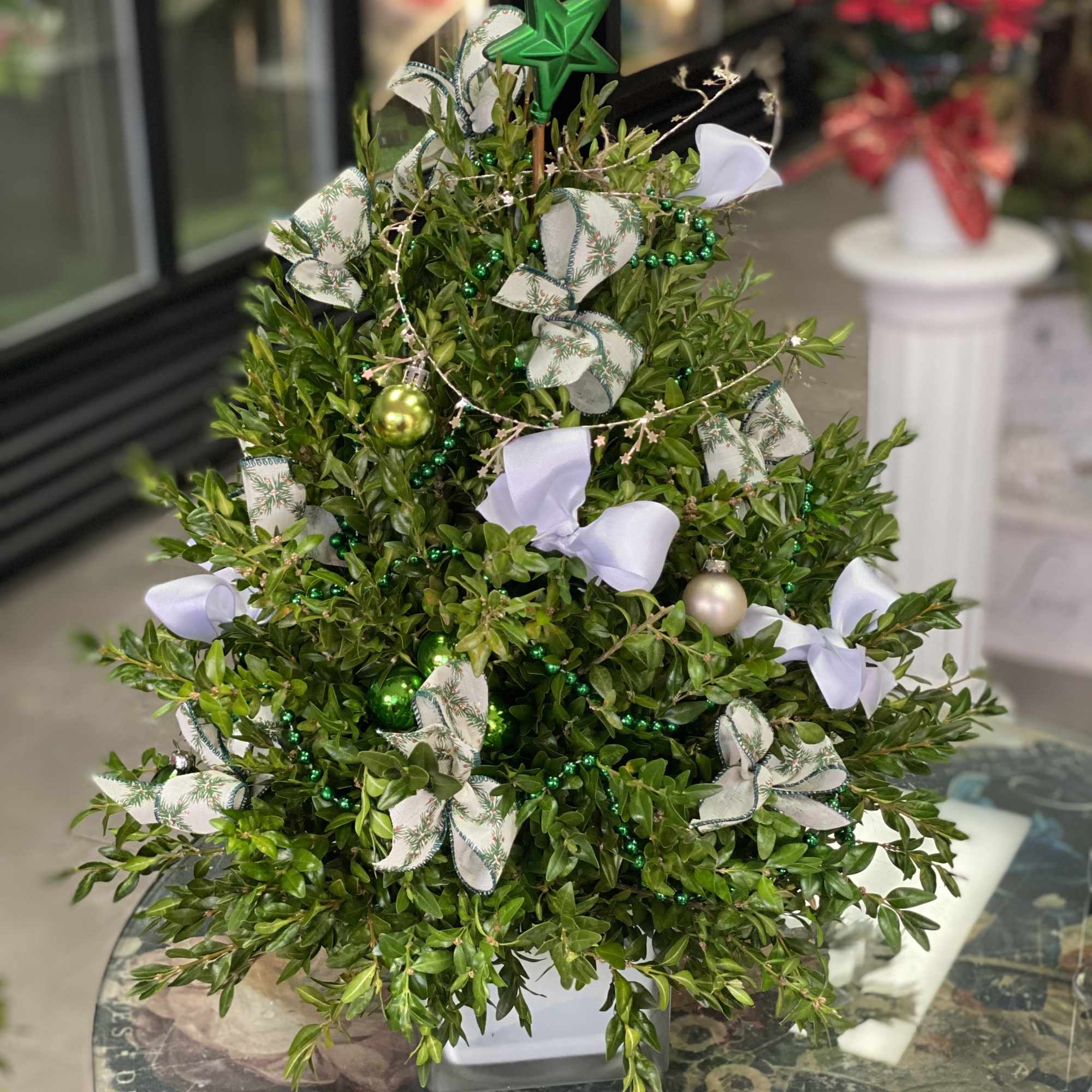 Christmas tree centerpiece made out of fresh greens and dressed up in