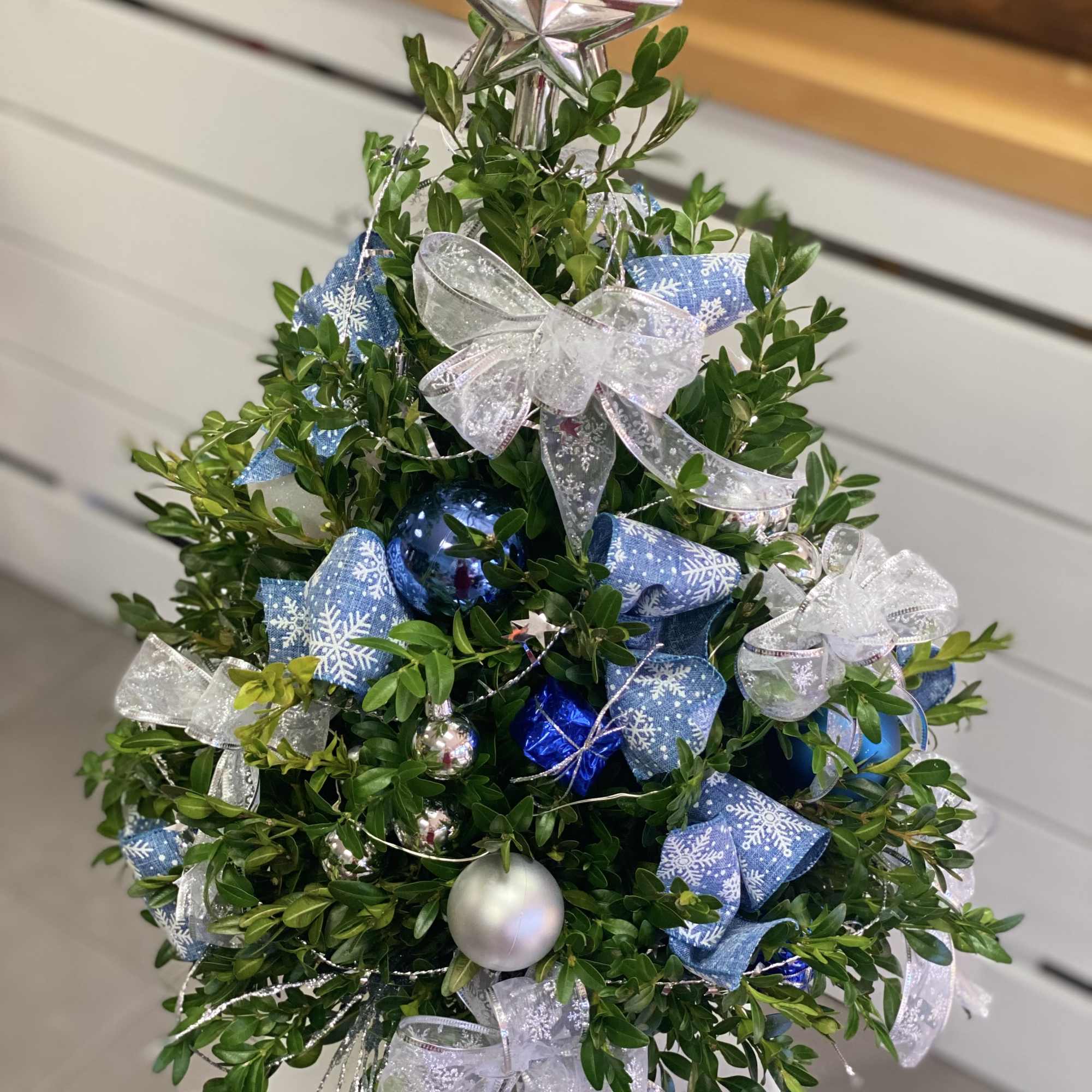 Christmas tree centerpiece made out of fresh greens and dressed up in