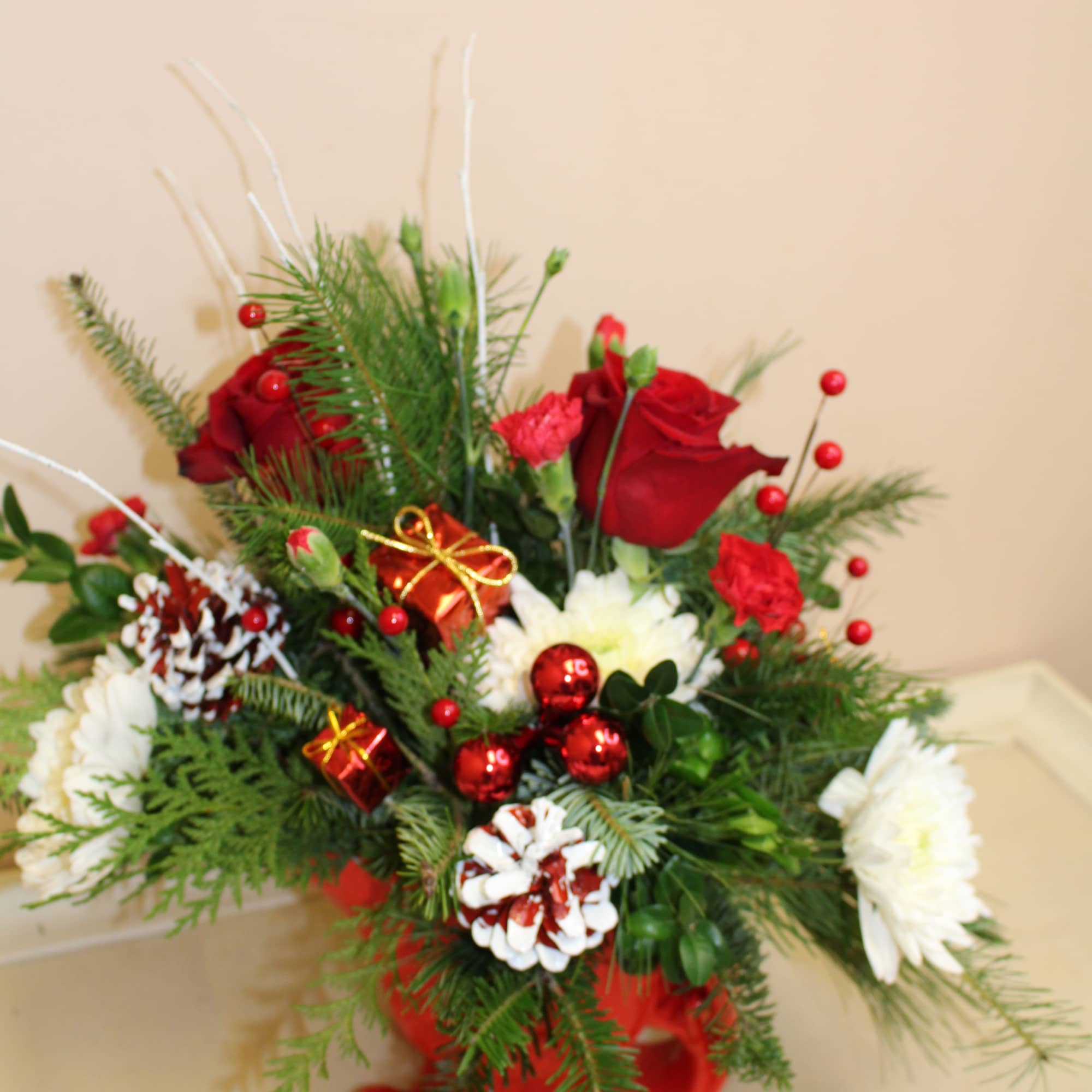 a ceramic red sleigh filled with a holiday arrangement