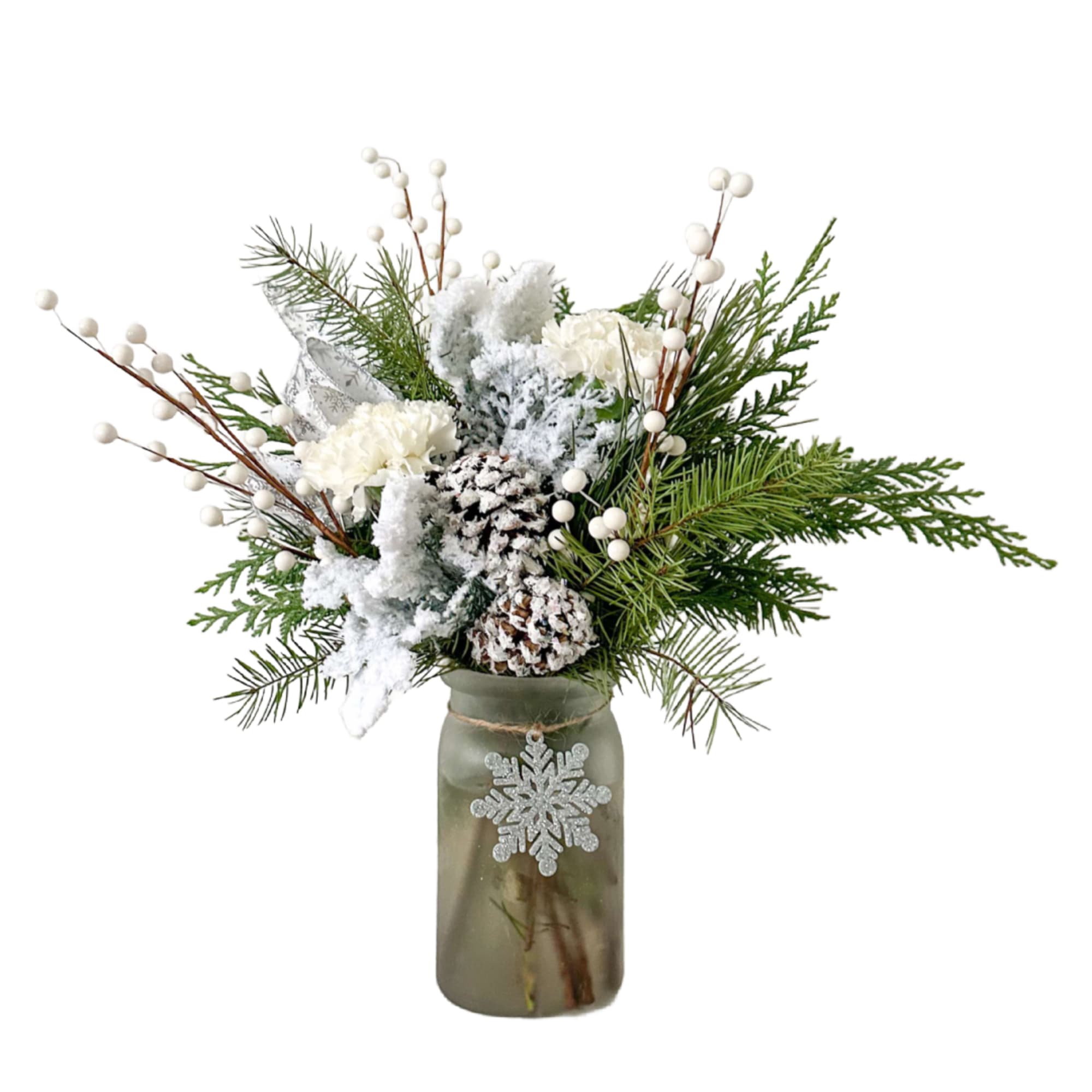 A snowy arrangement full of winter greens with a snowflake ornament. 
