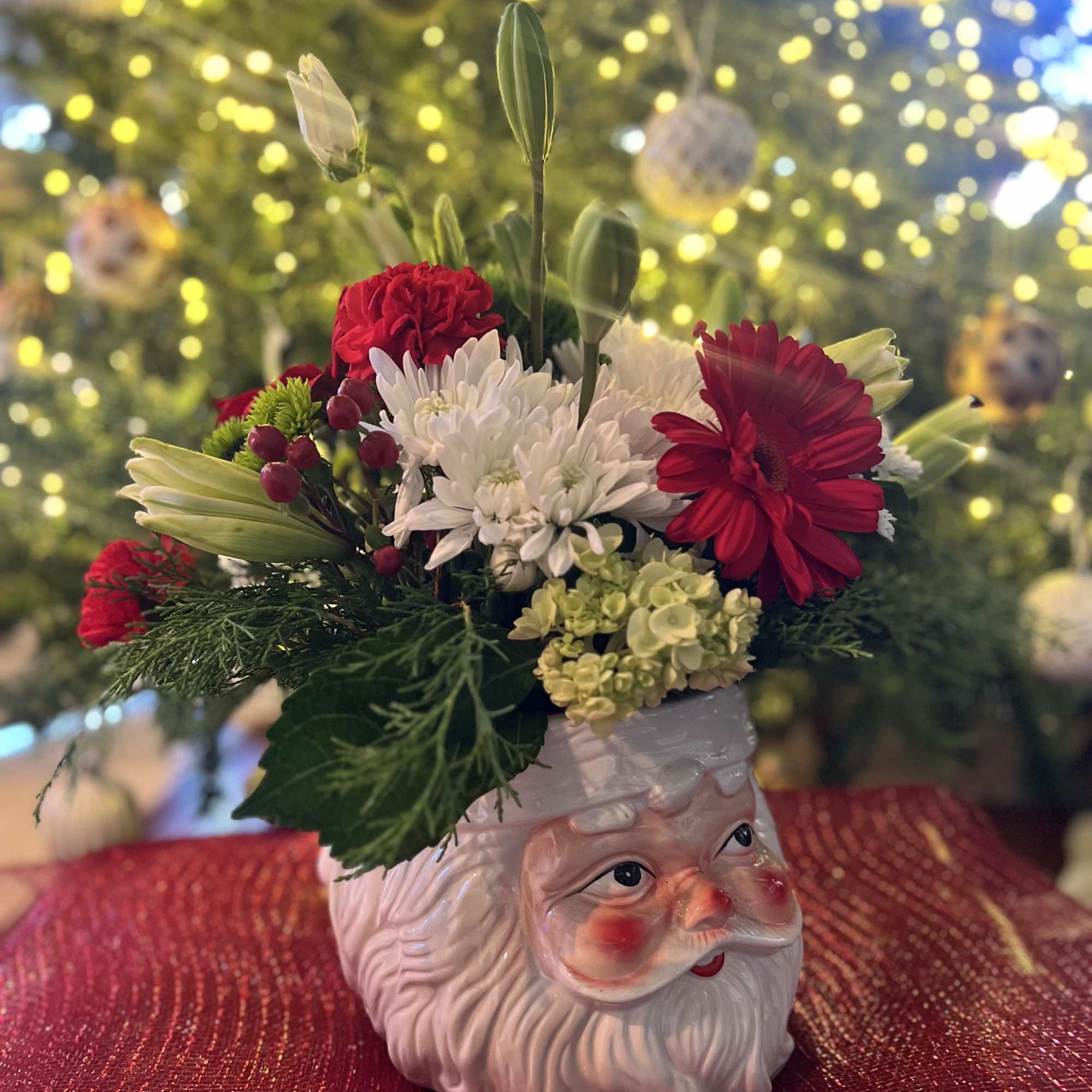 Designers Choice of Christmas florals placed on a large decorative &ldquo;SANTA CLAUSE&rdquo;