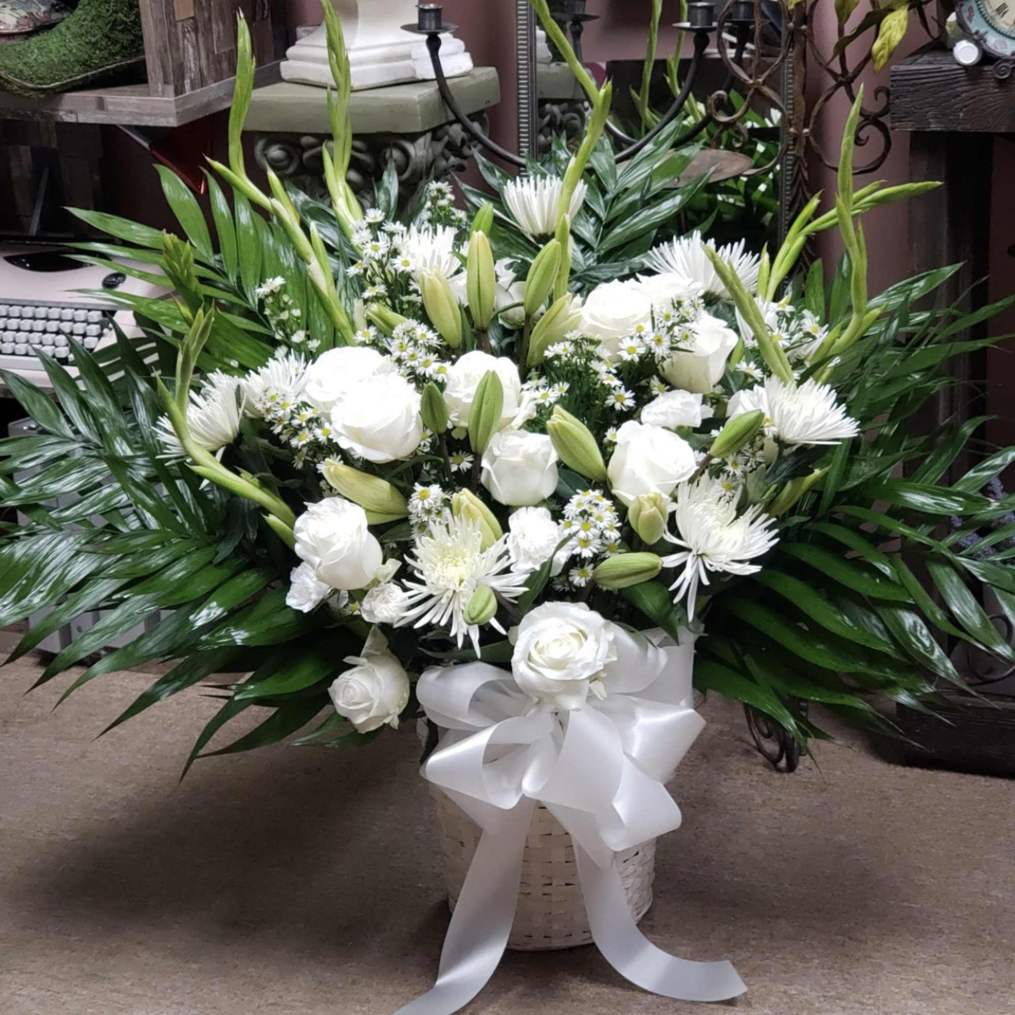Array of all white fresh cut florals with palms front facing arranged
