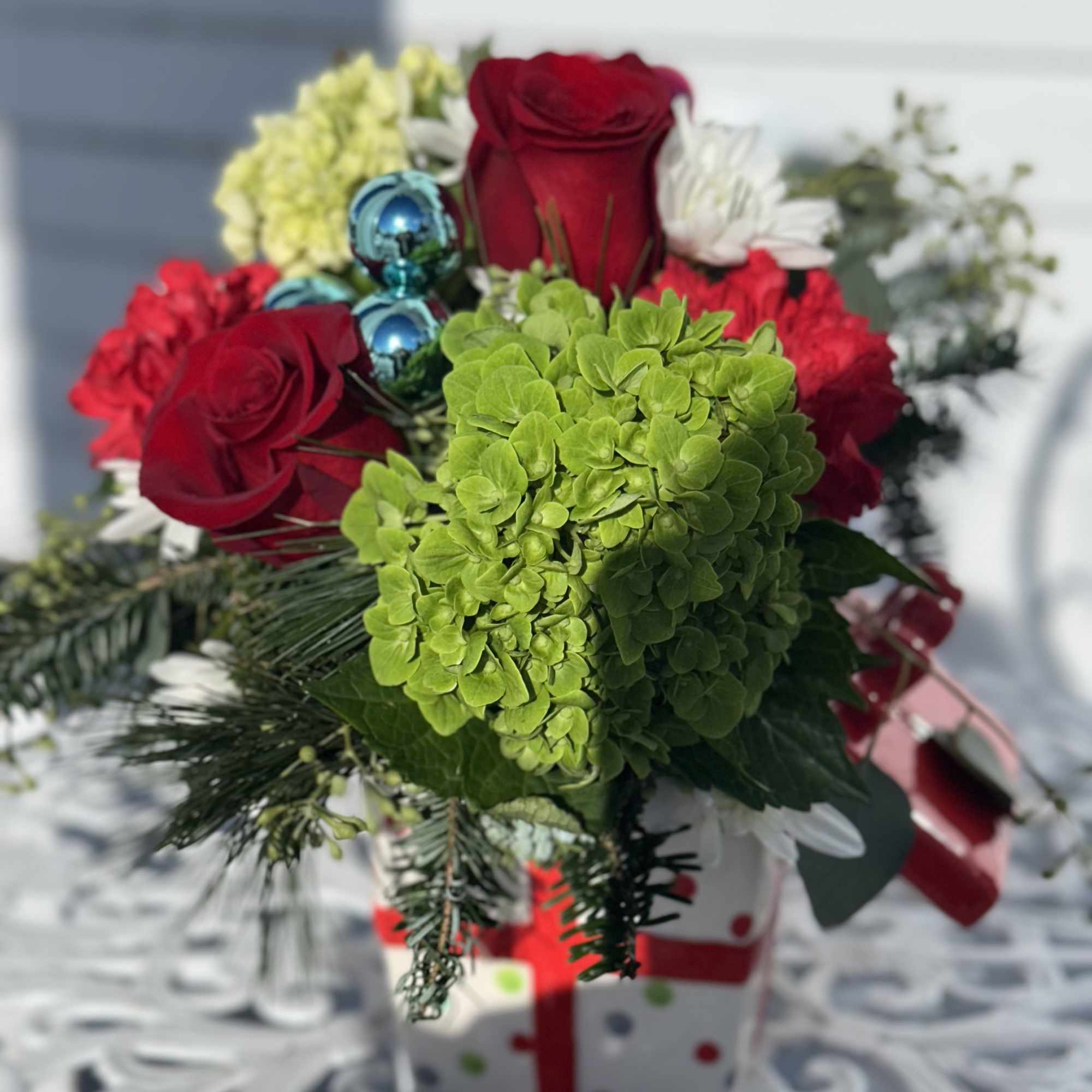 Ceramic present filled with red roses, carnations, green hydrangeas and white 
chrysanthemums