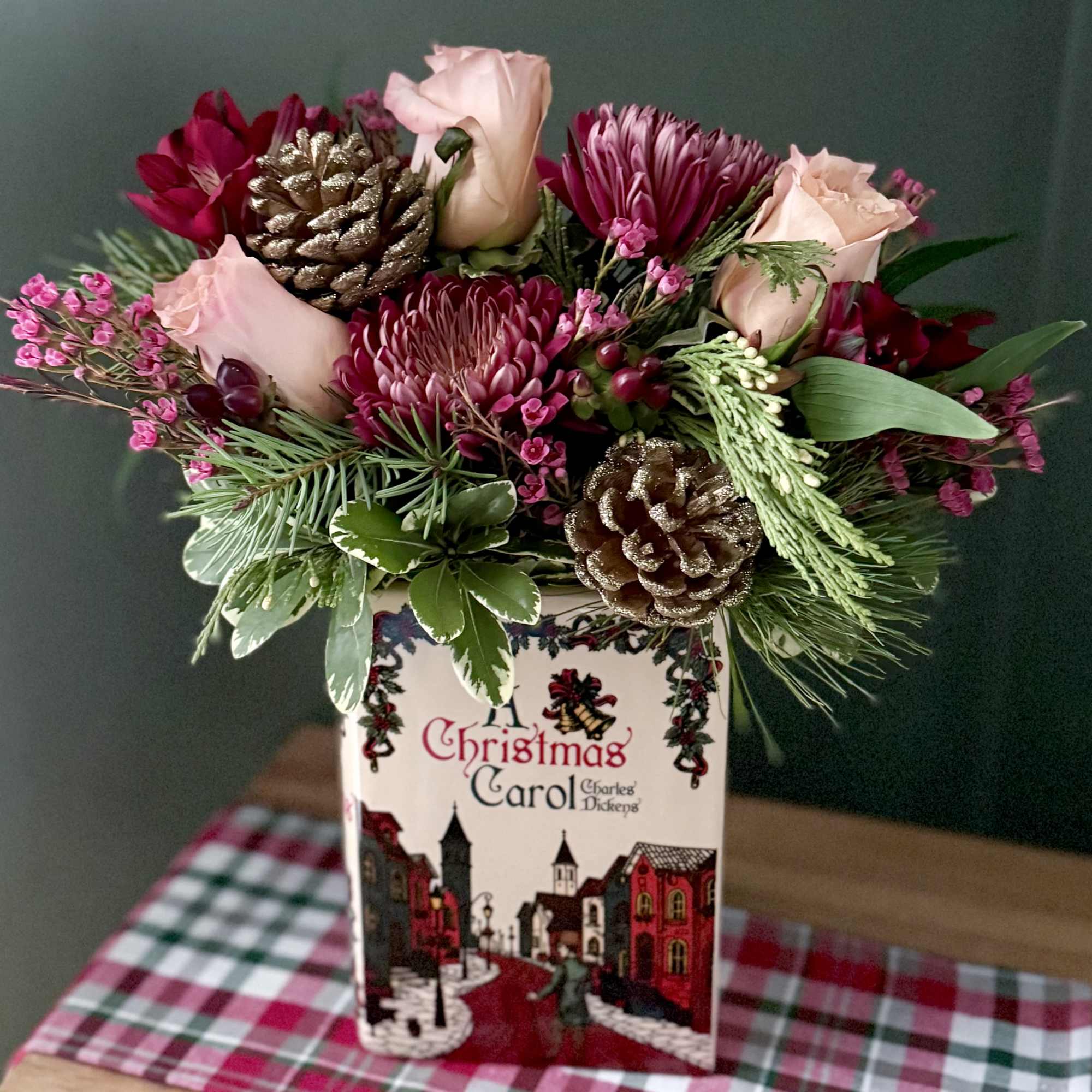 A ceramic vase in the shape of a book featuring a Christmas