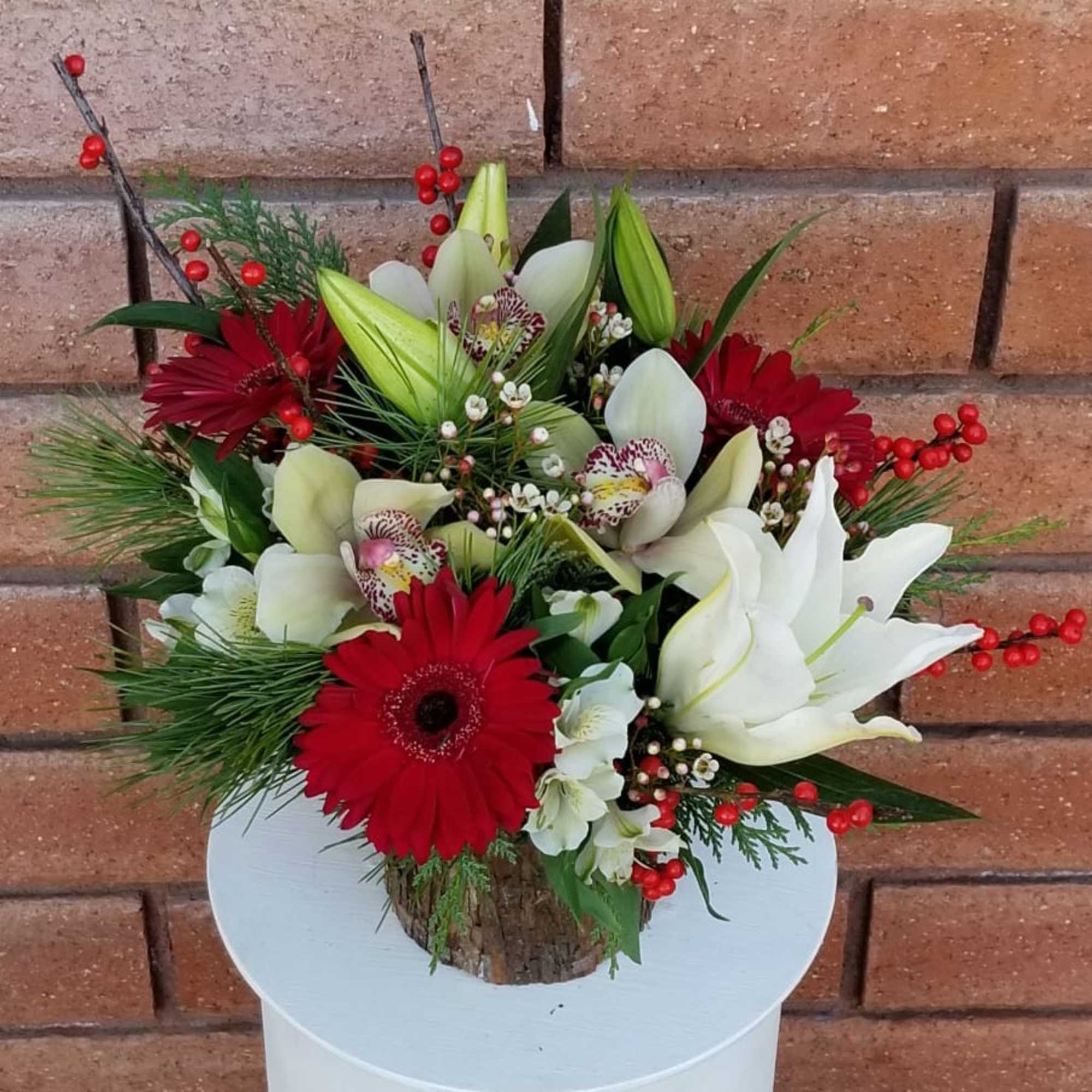 A festive and delightful arrangement of crystal blanca lilies, cymbidium orchids, red