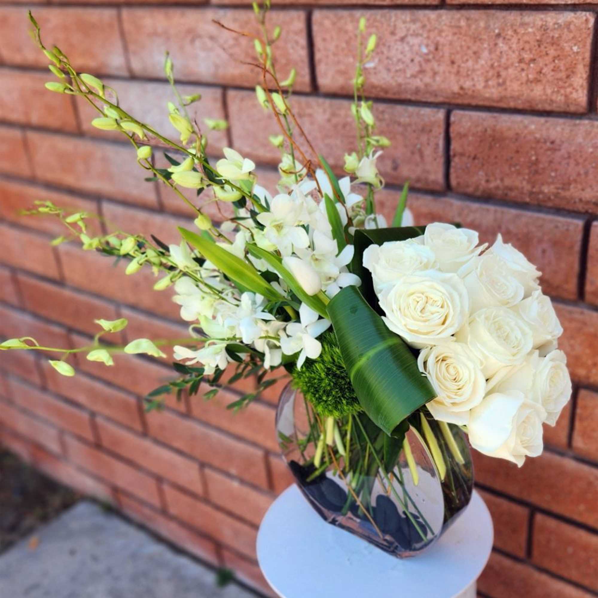 Simply gorgeous, artistically arranged bouquet of dendrobium orchids and tulips cozied up