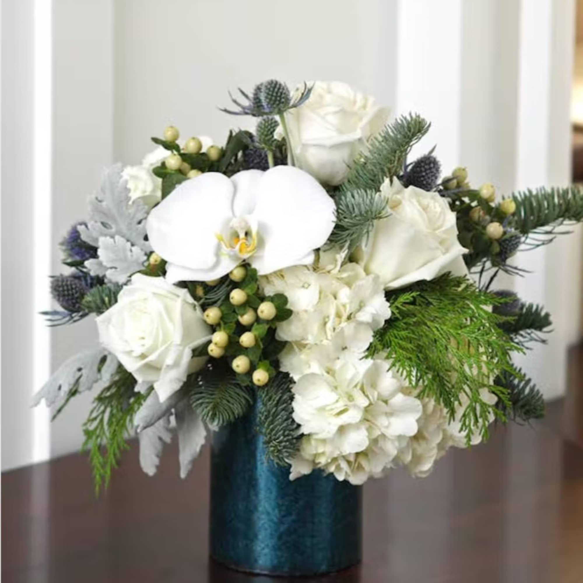 Our blue and white arrangement of fresh blue thistle, white roses, 