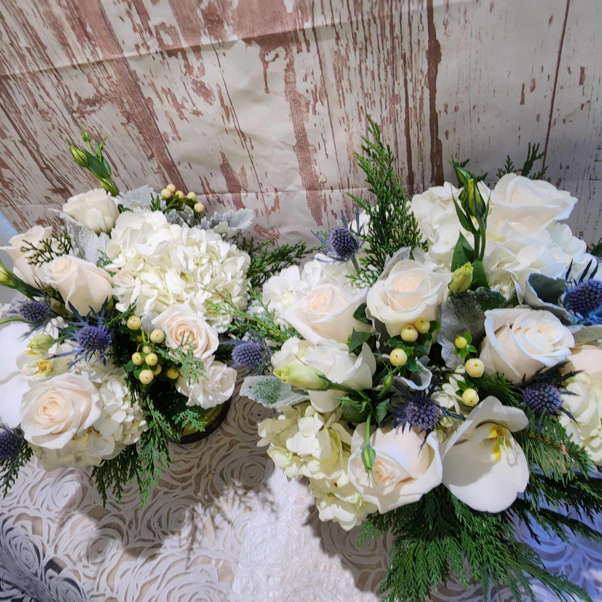 Our blue and white arrangement of fresh blue thistle, white roses, 