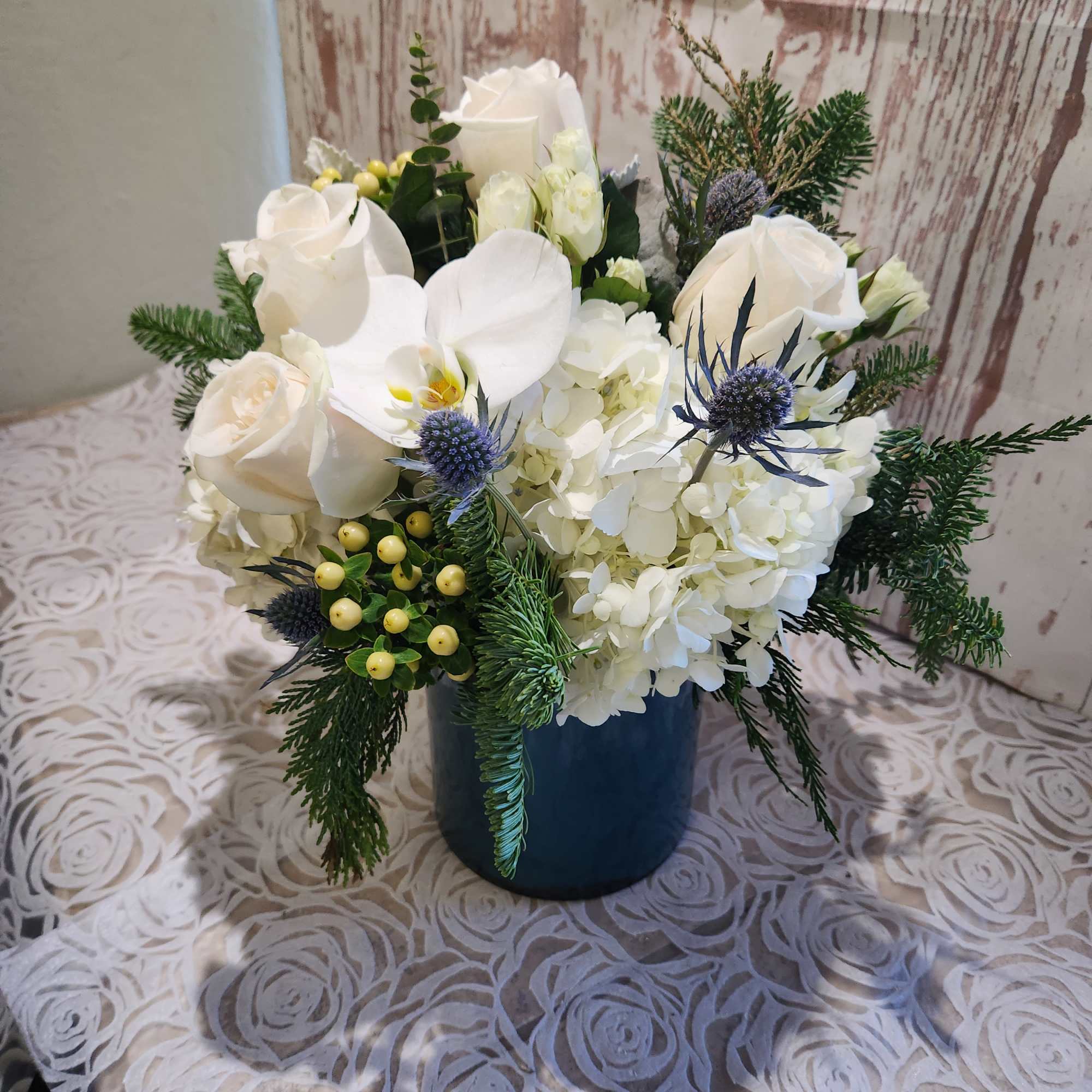 Our blue and white arrangement of fresh blue thistle, white roses, 
