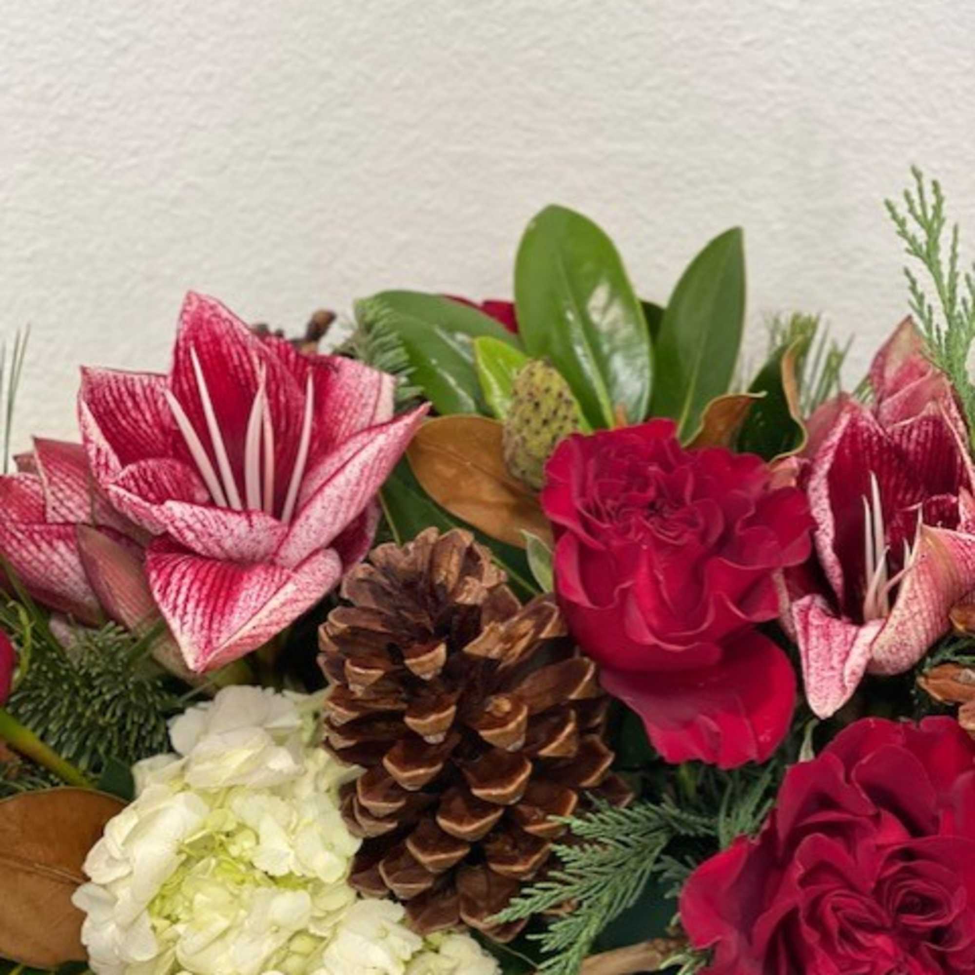 A gorgeous centerpiece with Amaryllis, Roses, Hydrangea and seasonal adornments.