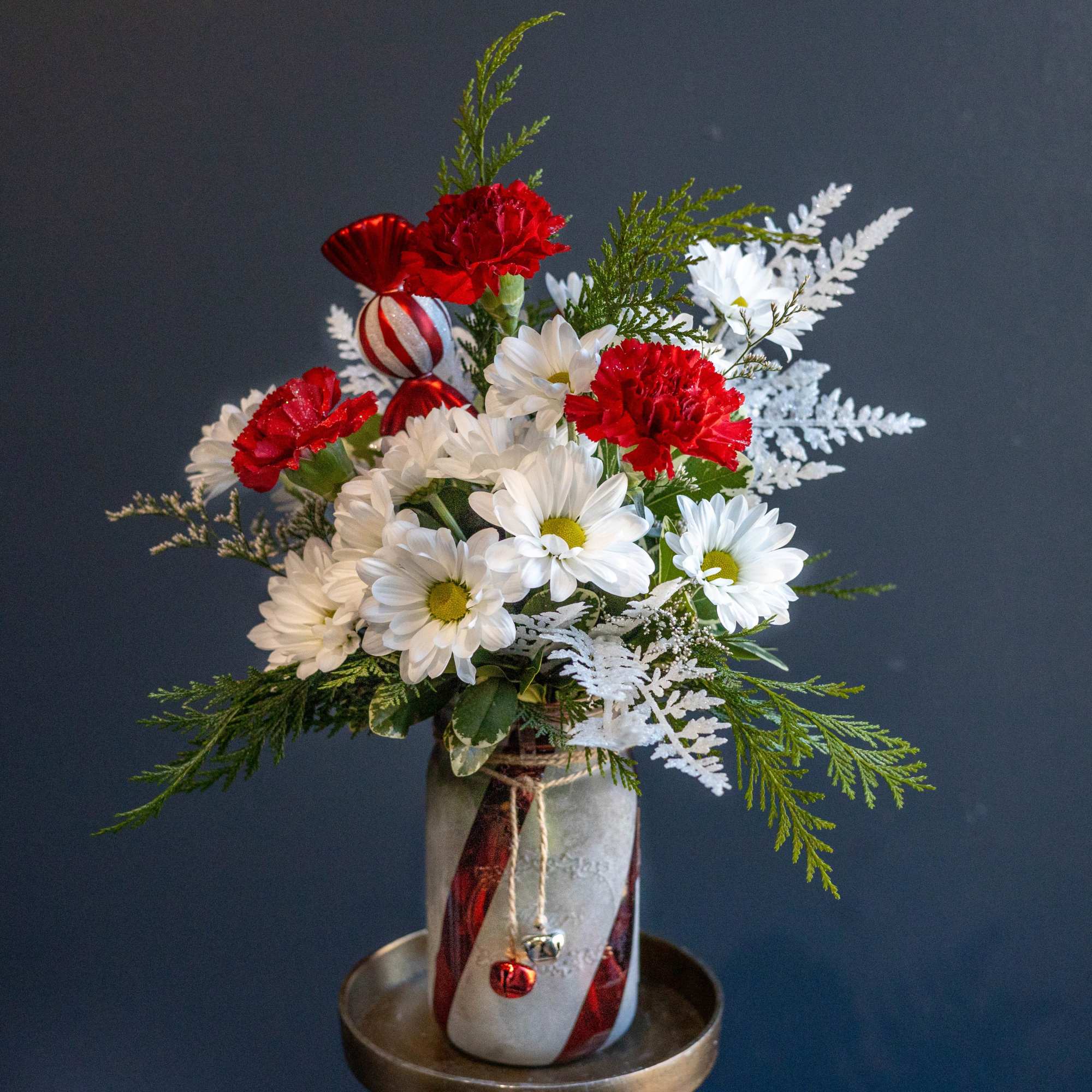 This frosted red and white candy cane vase adorned with a couple