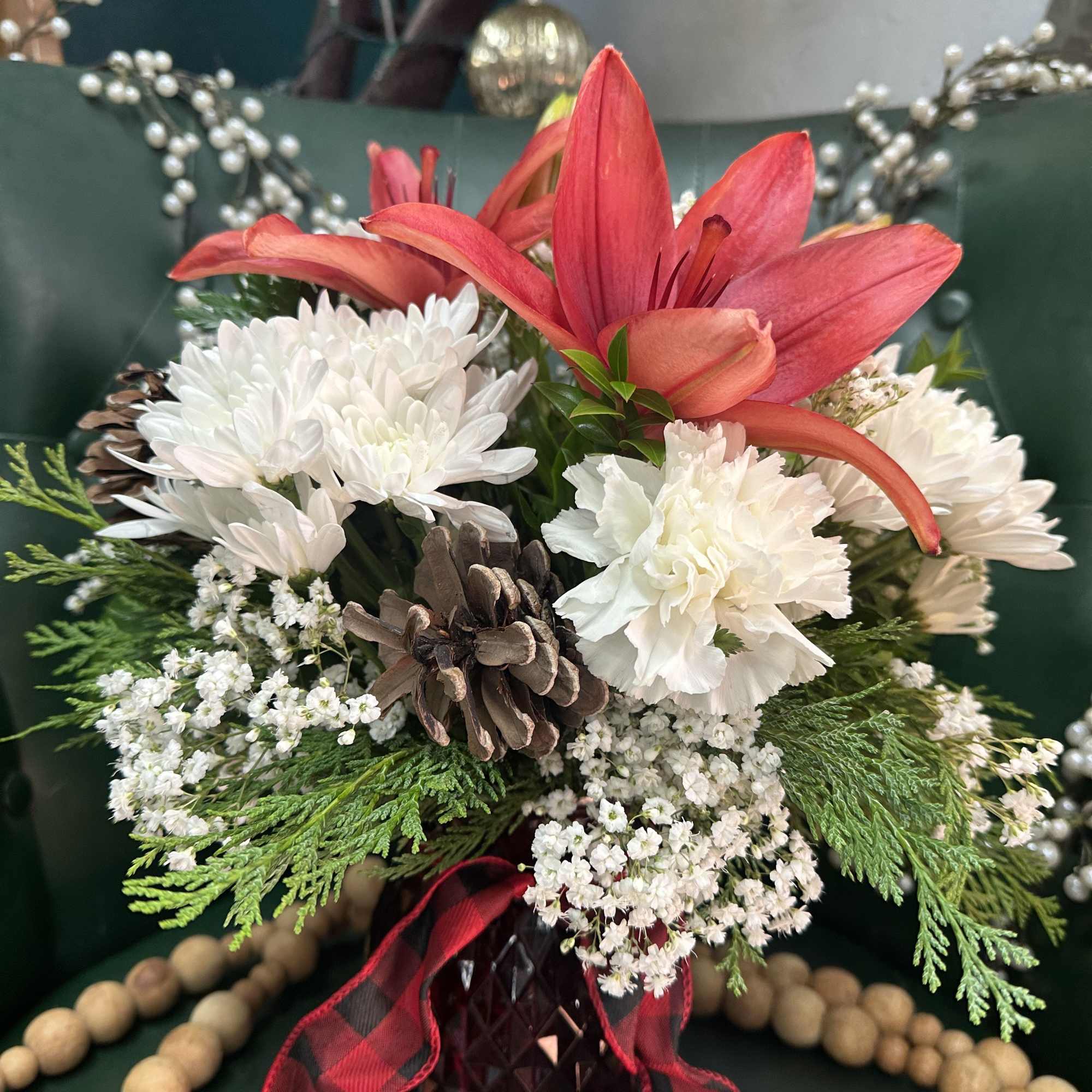 Crisp whites carnations and chrysanthemums paired with warm red lilies show off