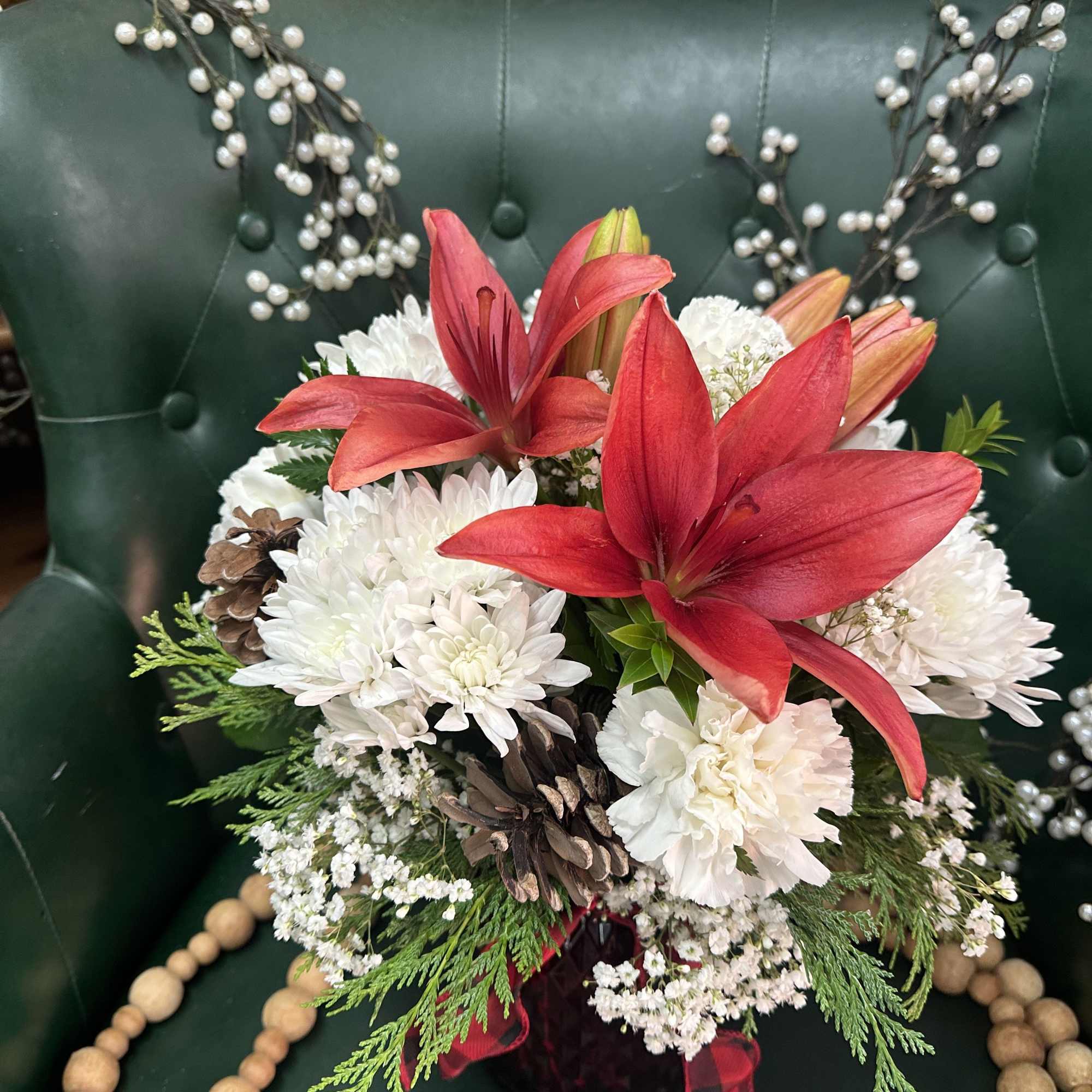 Crisp whites carnations and chrysanthemums paired with warm red lilies show off