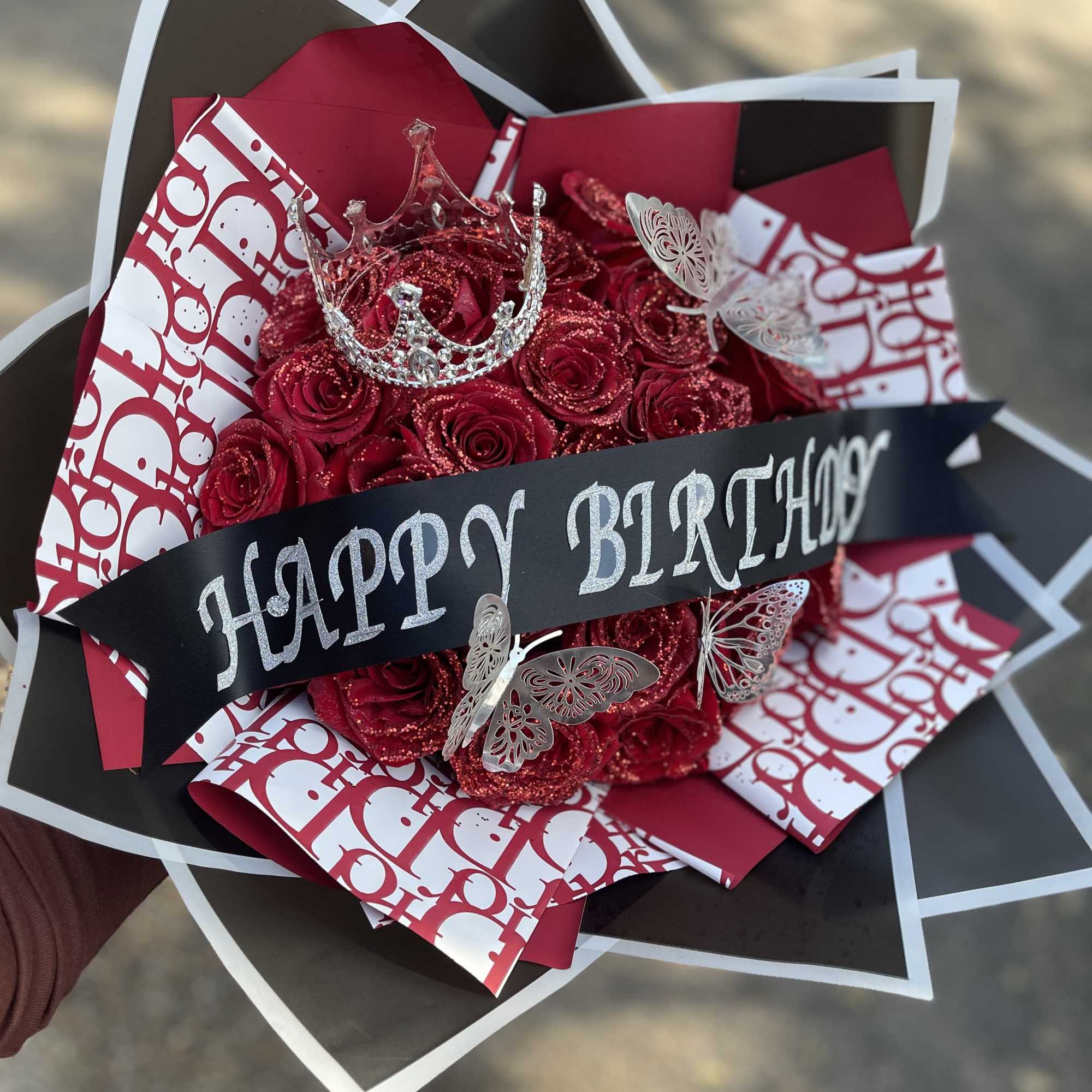 This arrangement will include  Red Glittered Roses wrapped in paper with