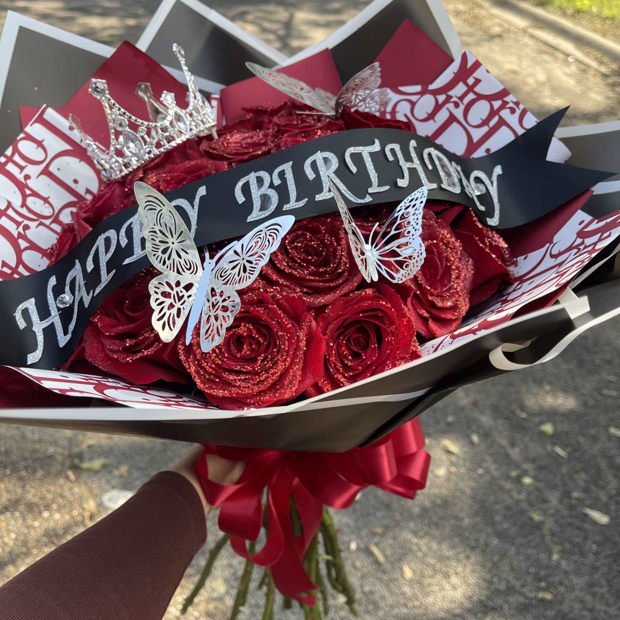 This arrangement will include  Red Glittered Roses wrapped in paper with