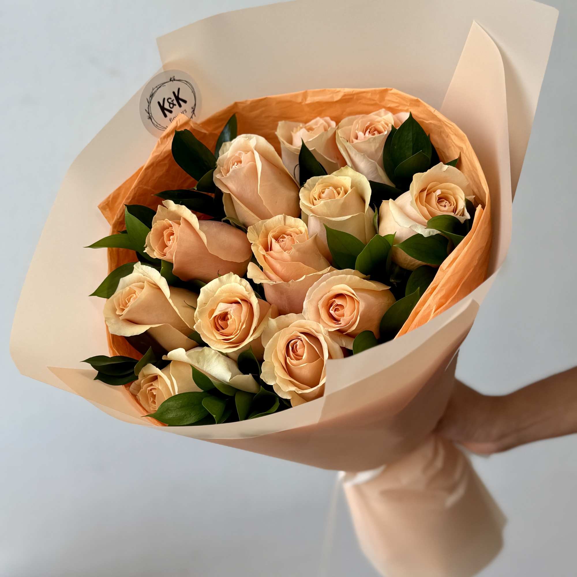 Peach Roses with greenery and decorative wrapping paper. All bouquets come without