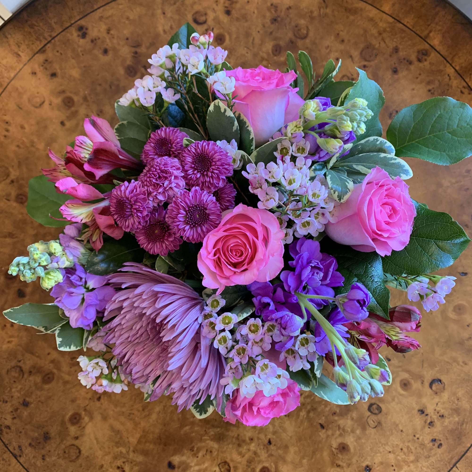 Pink roses, medium purple stock, purple pom buttons, hot pink alstromeria, and