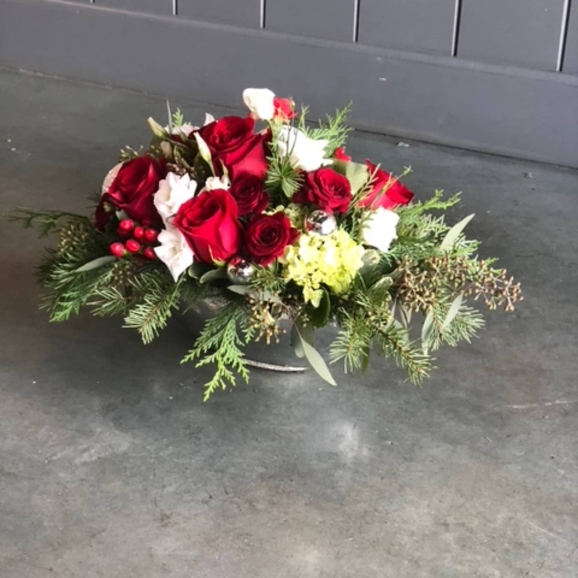 Christmas colors with seasonal flowers, evergreens and holiday accents.
