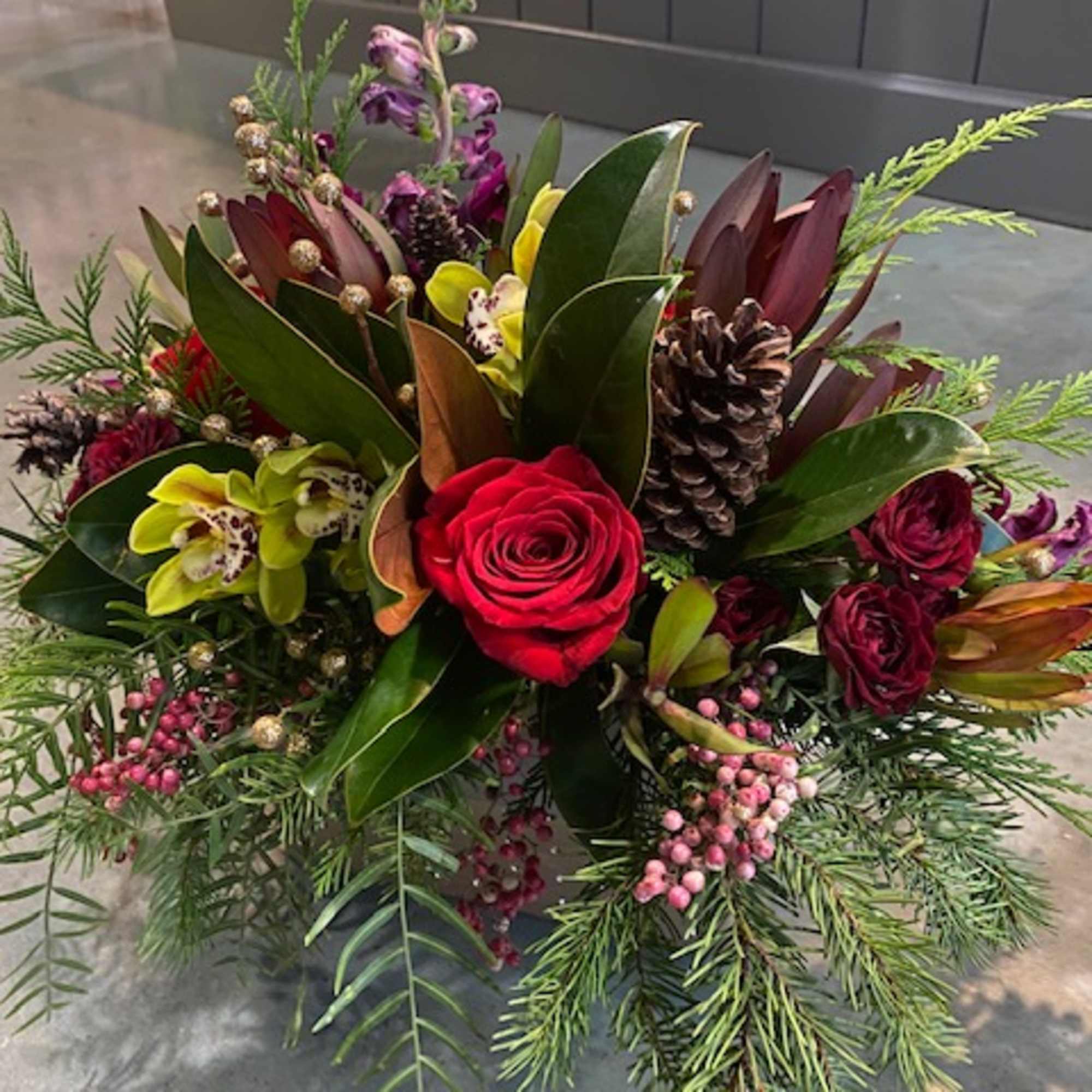 Christmas colors with seasonal flowers, evergreens and holiday accents.
