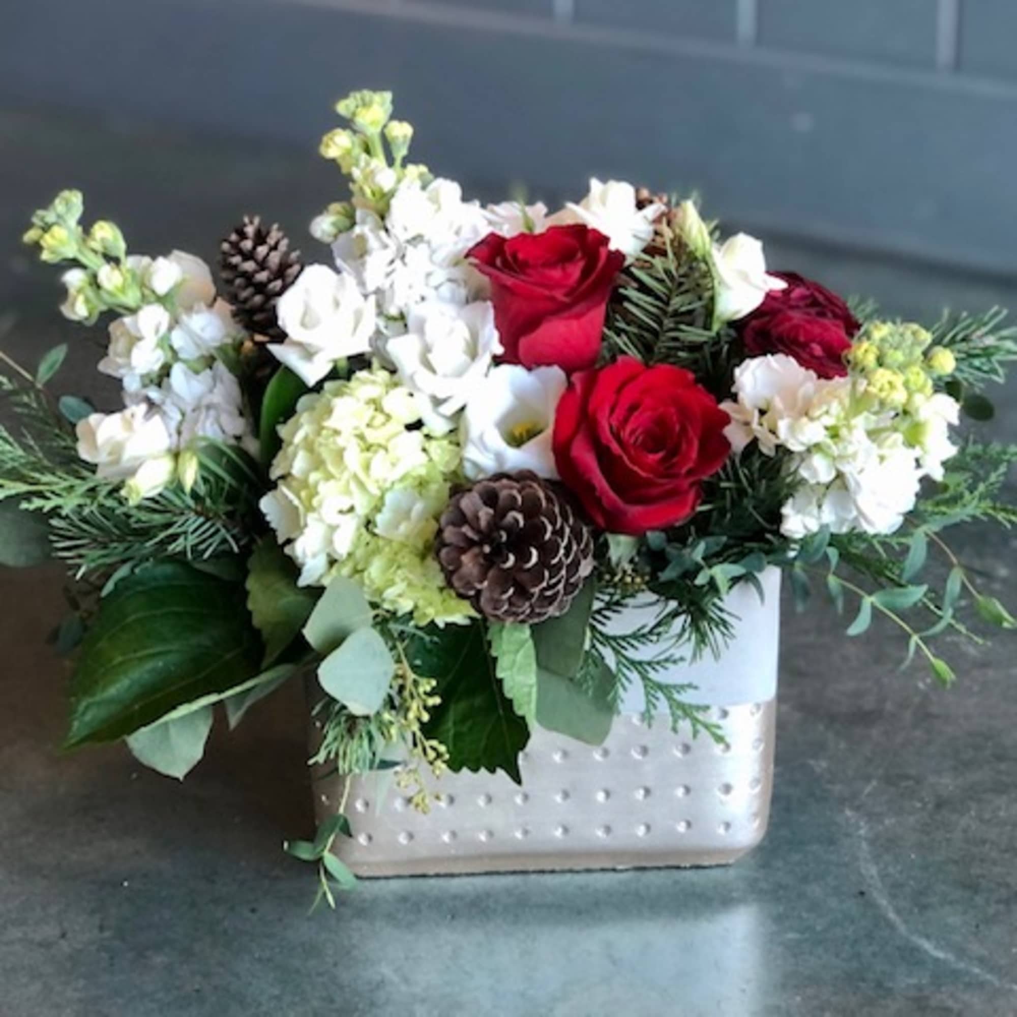 Christmas colors with seasonal flowers, evergreens and holiday accents.
