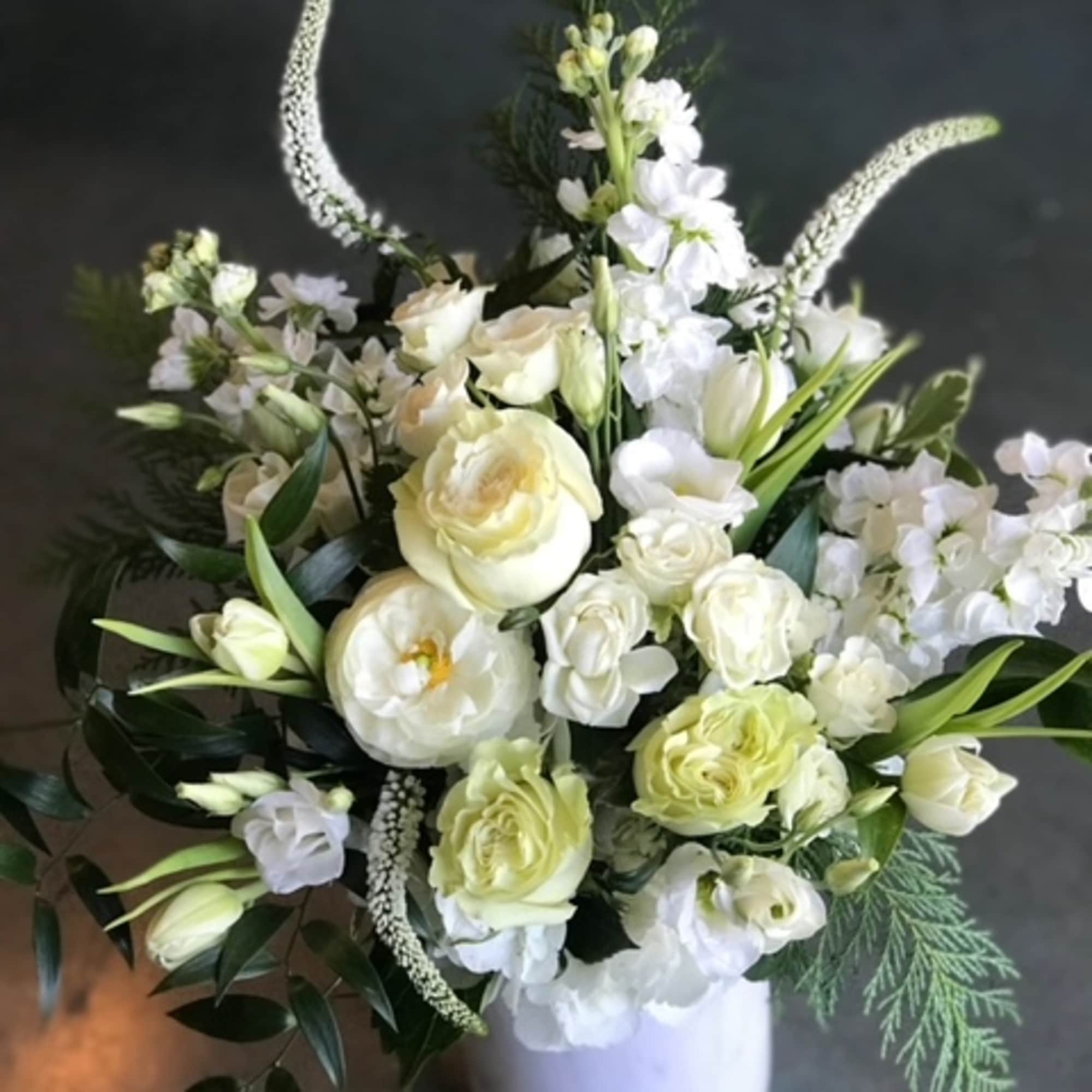 Christmas colors with seasonal flowers, evergreens and holiday accents.