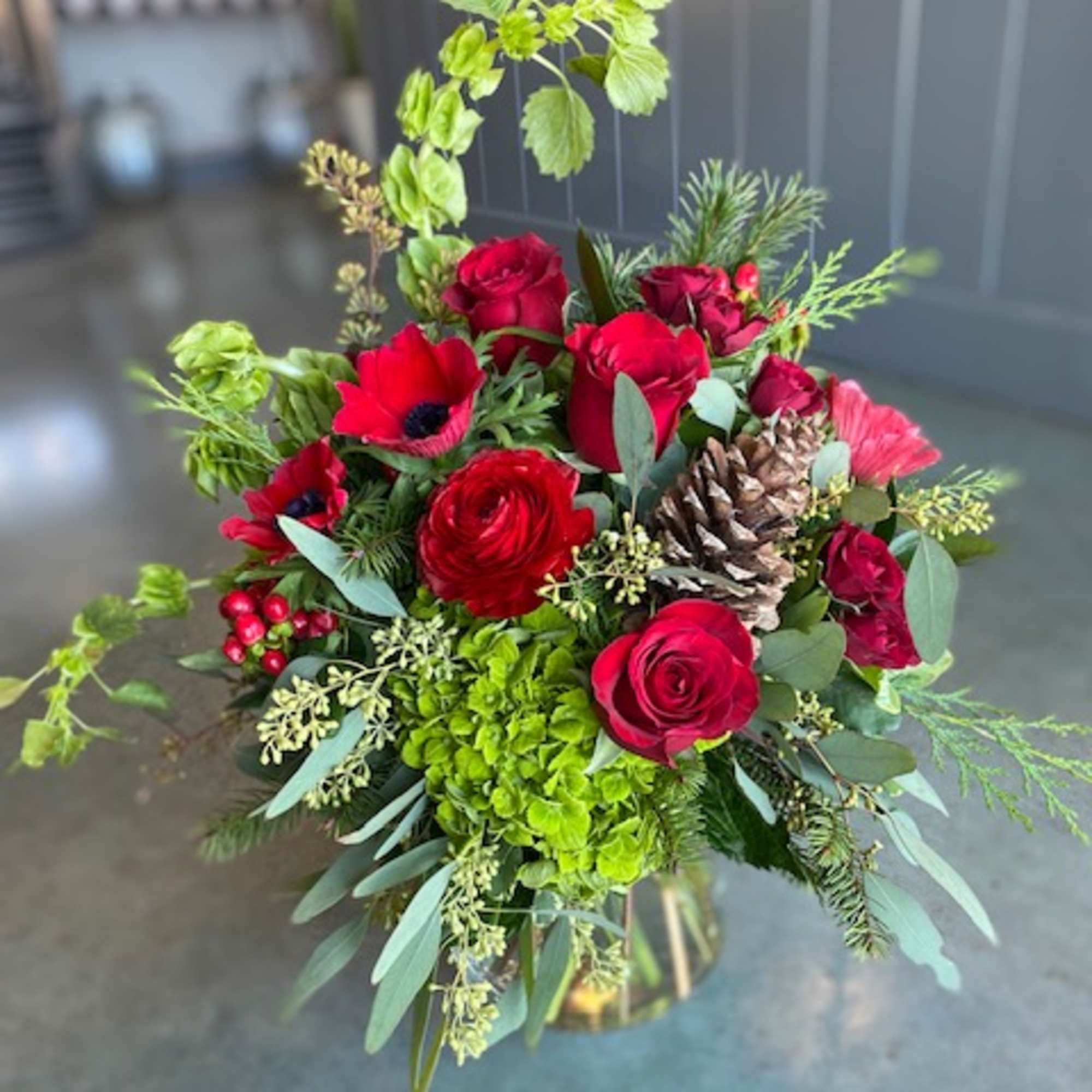 Christmas colors with seasonal flowers, evergreens and holiday accents.