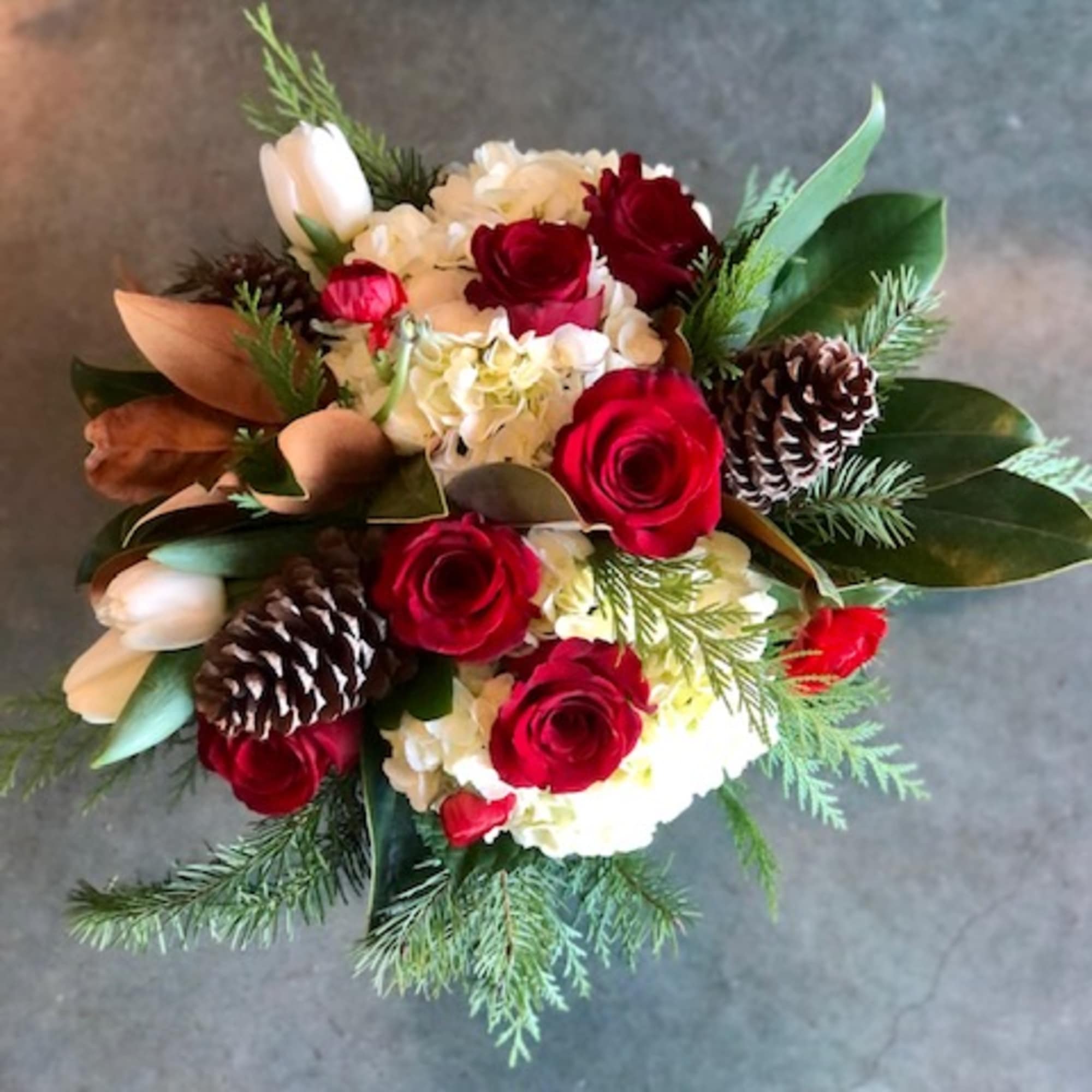 Christmas colors with seasonal flowers, evergreens and holiday accents.