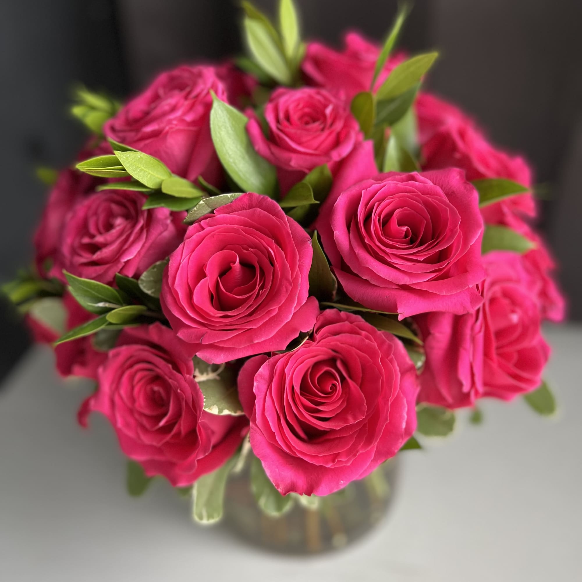 12 premium hot pink roses in a low and lush style

