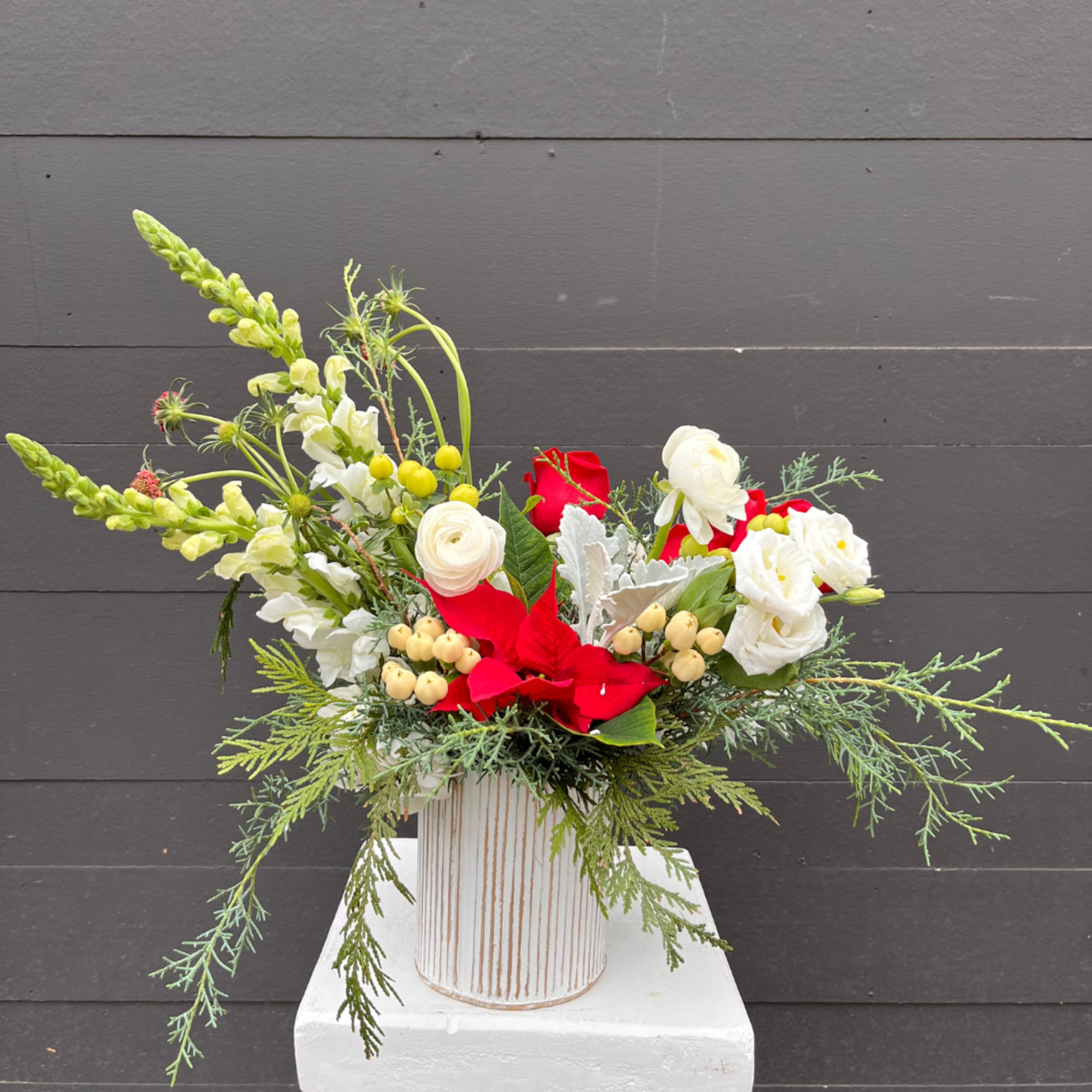 A festive Holiday Arrangement is a cheerful and elegant display inspired by