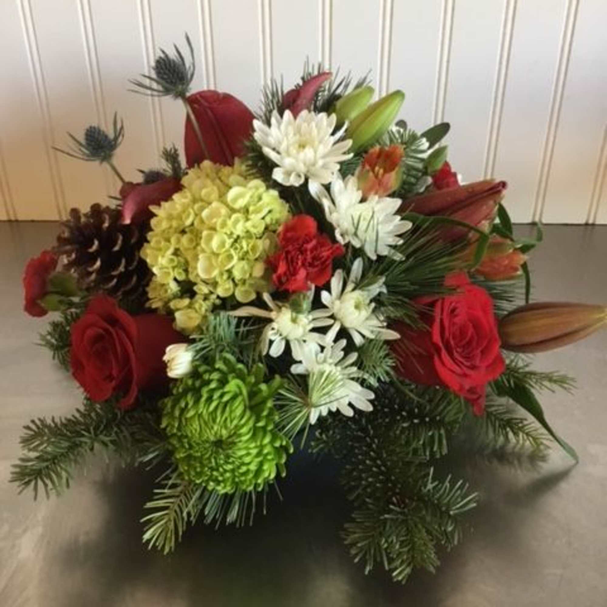 A lovely gathering-table centerpiece of reds, greens and whites with seasonal touches