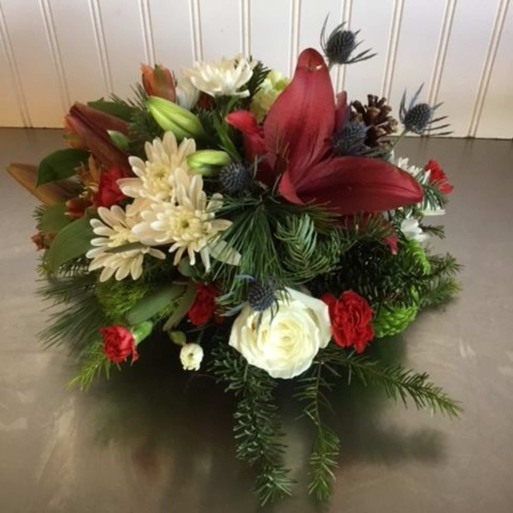 A lovely gathering-table centerpiece of reds, greens and whites with seasonal touches
