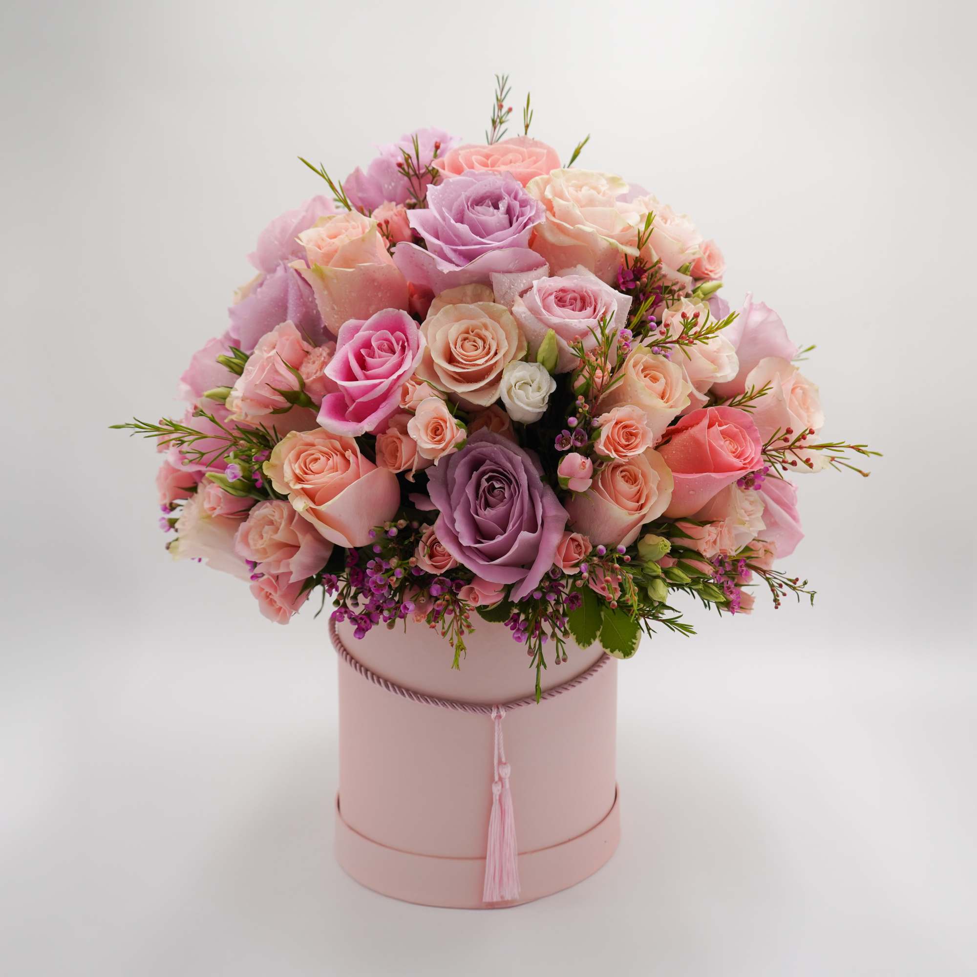 Different shade of pink flowers are carefully arranged inside the flower box.