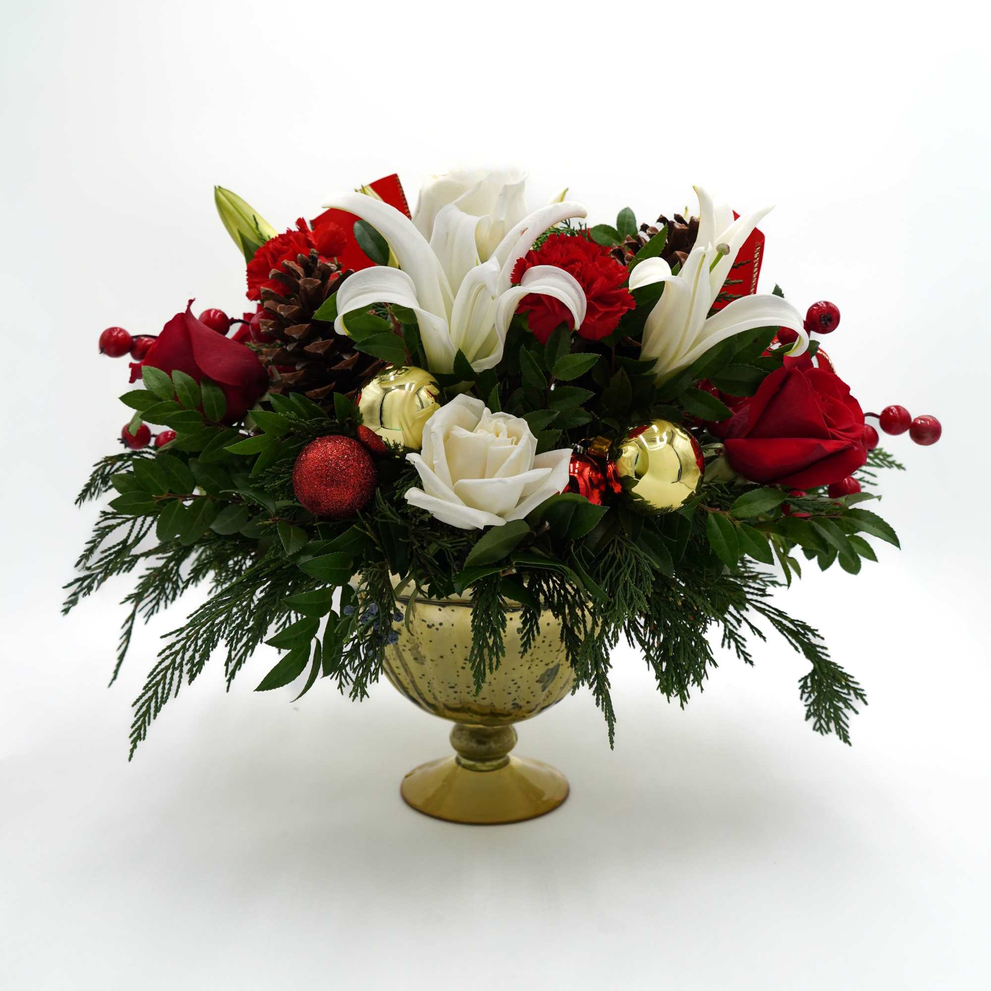 Includes white and red roses, lilies, carnations, pinecones, Christmas ornaments, and Pine