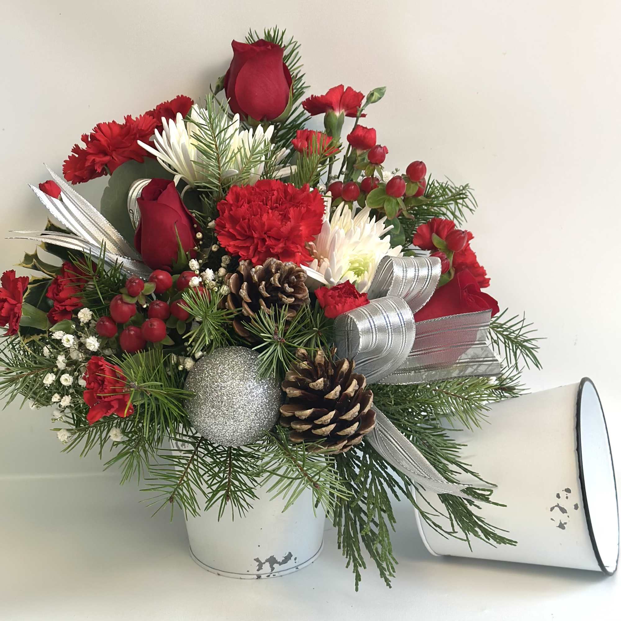 This rustic white metal container is filled with traditional colors of Christmas.
