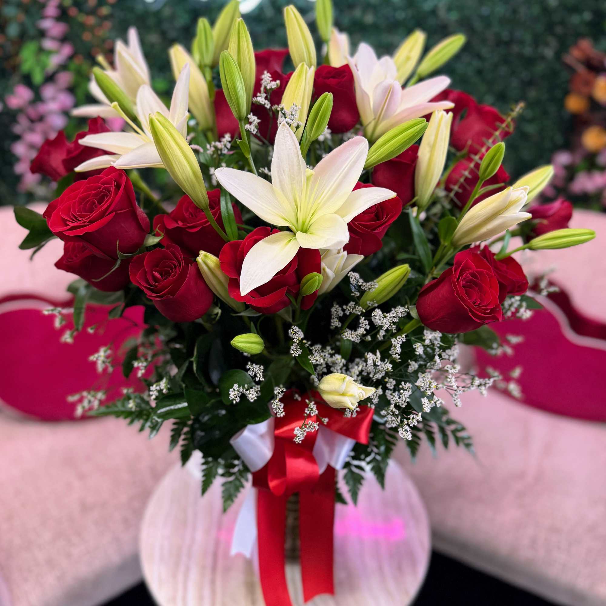 Beautiful fresh red roses paired with elegant white lilies, arranged in a