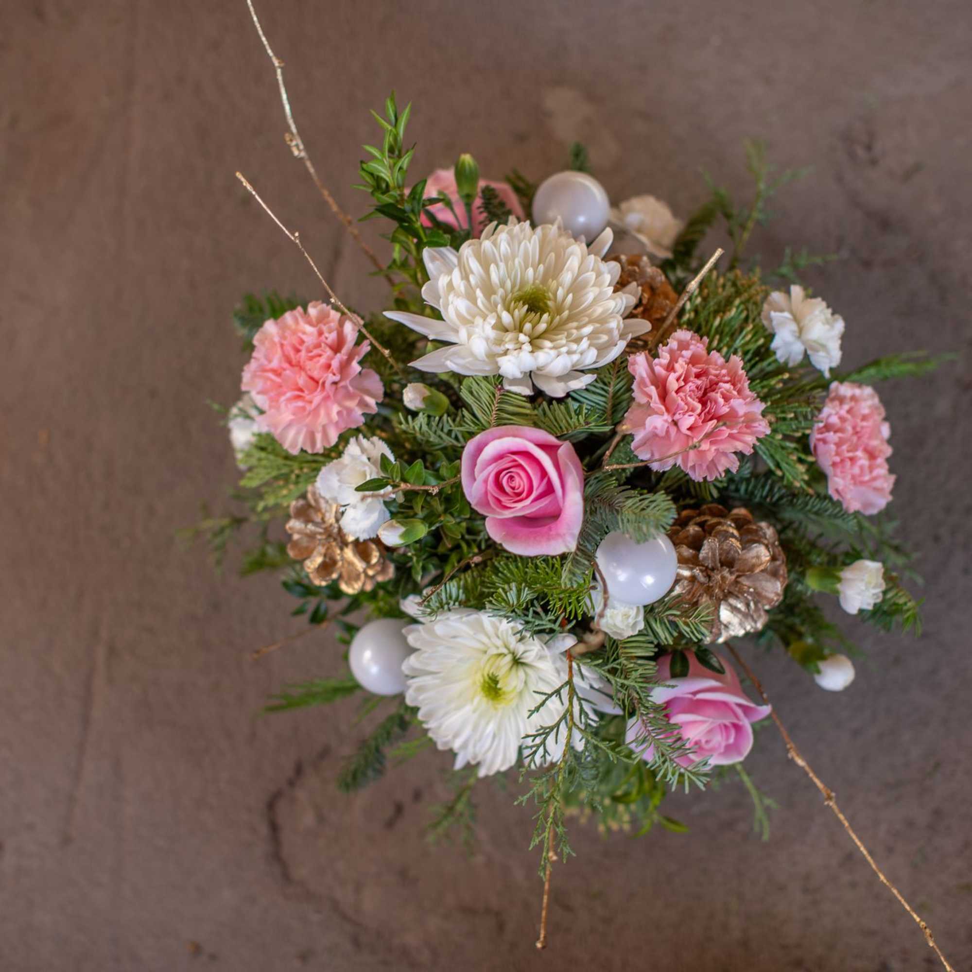 Artfully arranged winter foliage varieties are nested in a lovely golden bowl.