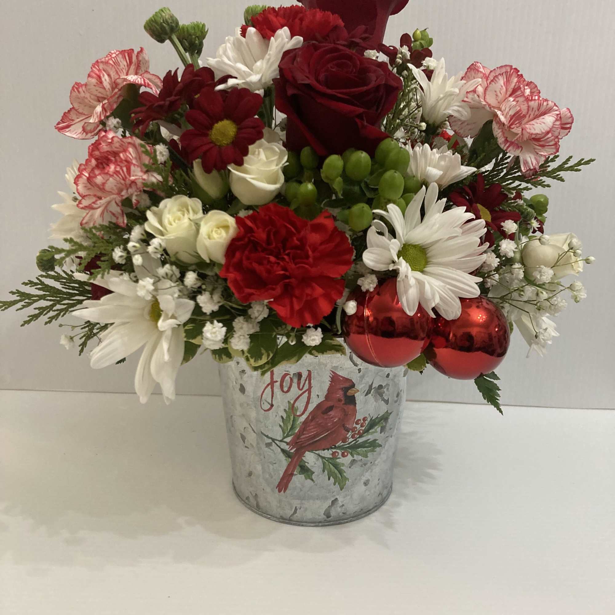 Exquisite arrangement with in a beautiful cardinal designers pot with roses, carnations