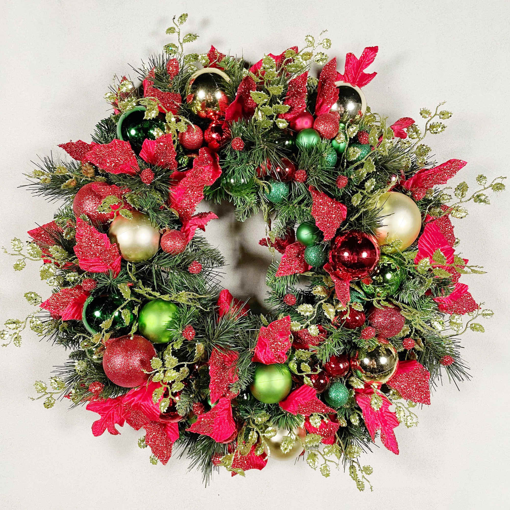 A traditional holiday wreath with beautiful red and green ornaments and a
